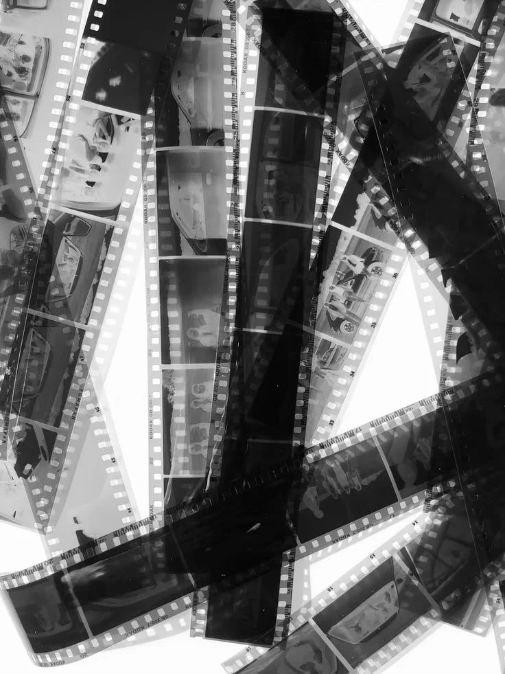 A collection of overlapping black and white photographic film strips with various images on them.