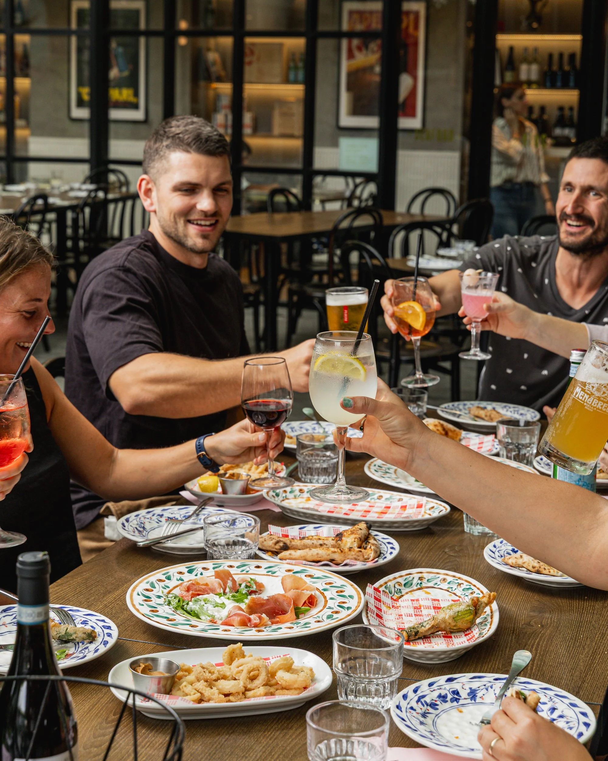 Big Birthday Celebration of a group of people eating Italian food and cheering in Chatswood