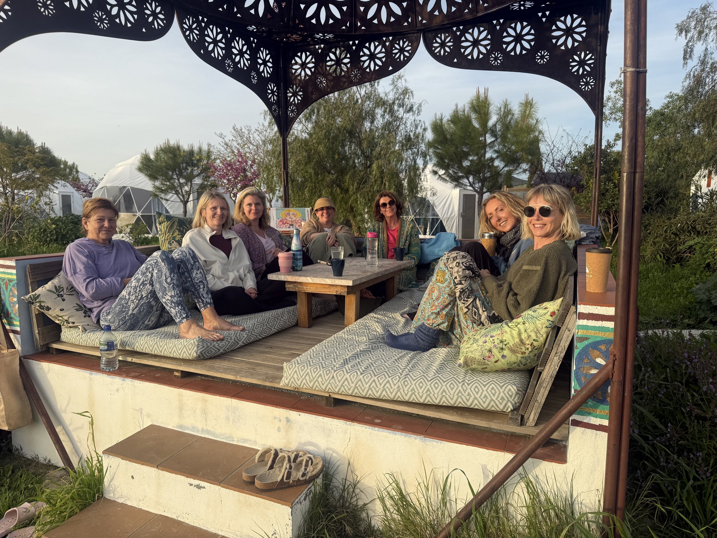 Smiling women at a Love Sober retreat in a beautiful, sun lit Moroccan gazebo