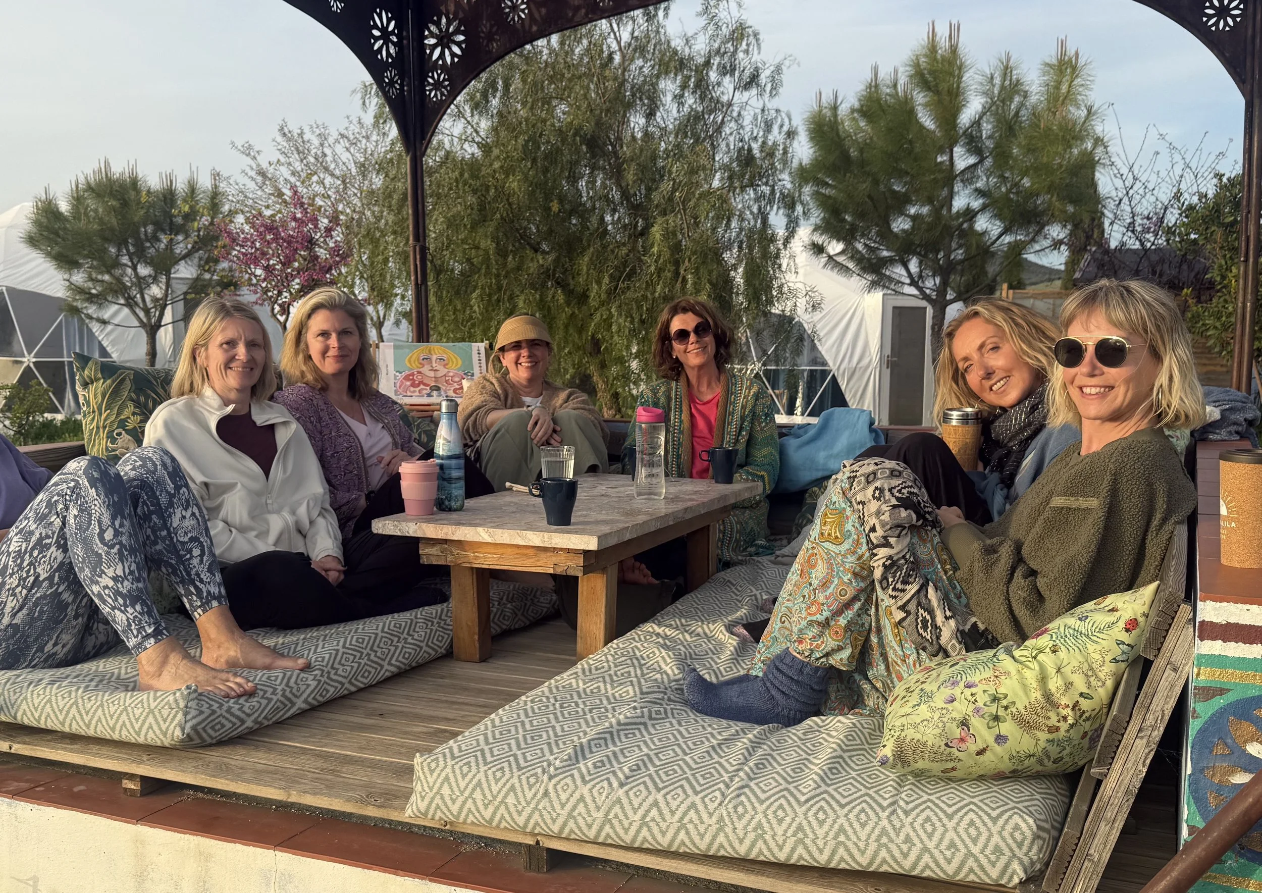 Smiling women at a Love Sober retreat in a beautiful, sun lit Moroccan gazebo