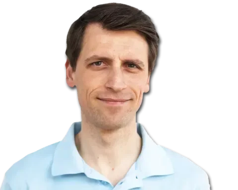 Retrato de un hombre de piel clara, pelo castaño corto, vestido con un polo azul claro, sonriendo ligeramente, sobre un fondo transparente.