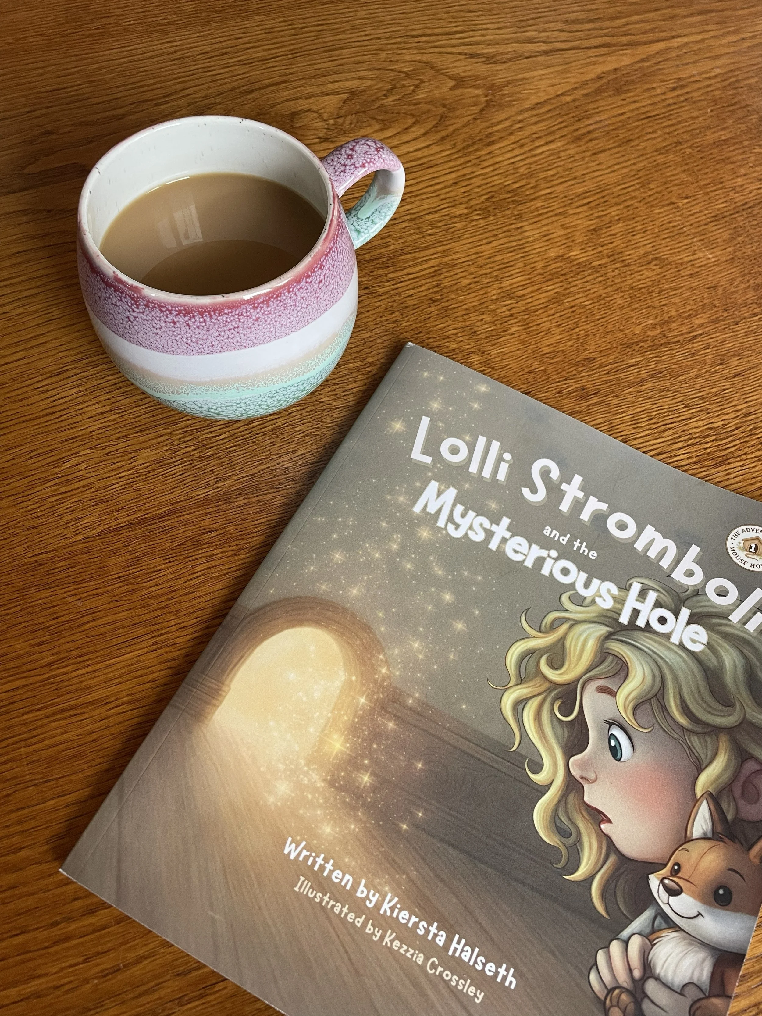 Parent enjoying a warm drink beside a copy of Lolli Stromboli and the Mysterious Hole during a bedtime reading routine.