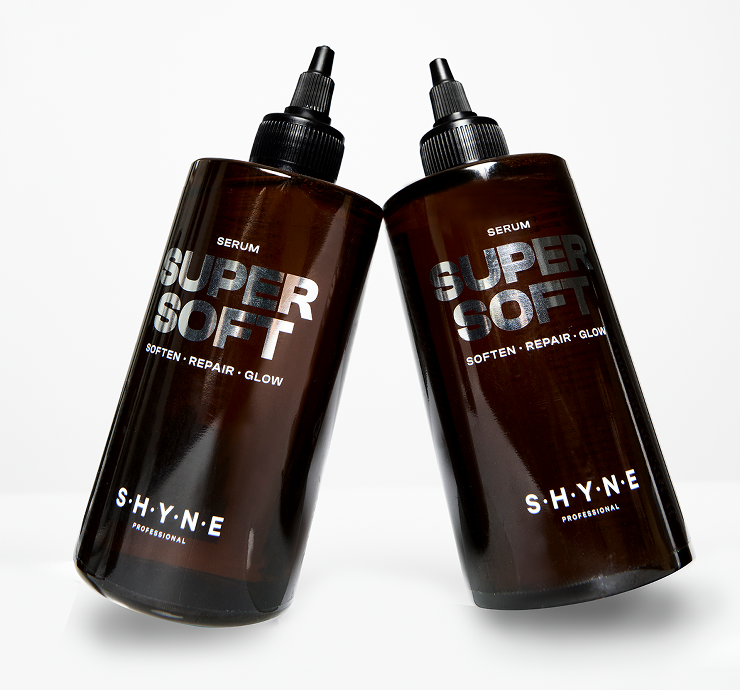 Two brown bottles with black caps and nozzle tips, labeled 'SHYNE Professional Serum' on a white background.
