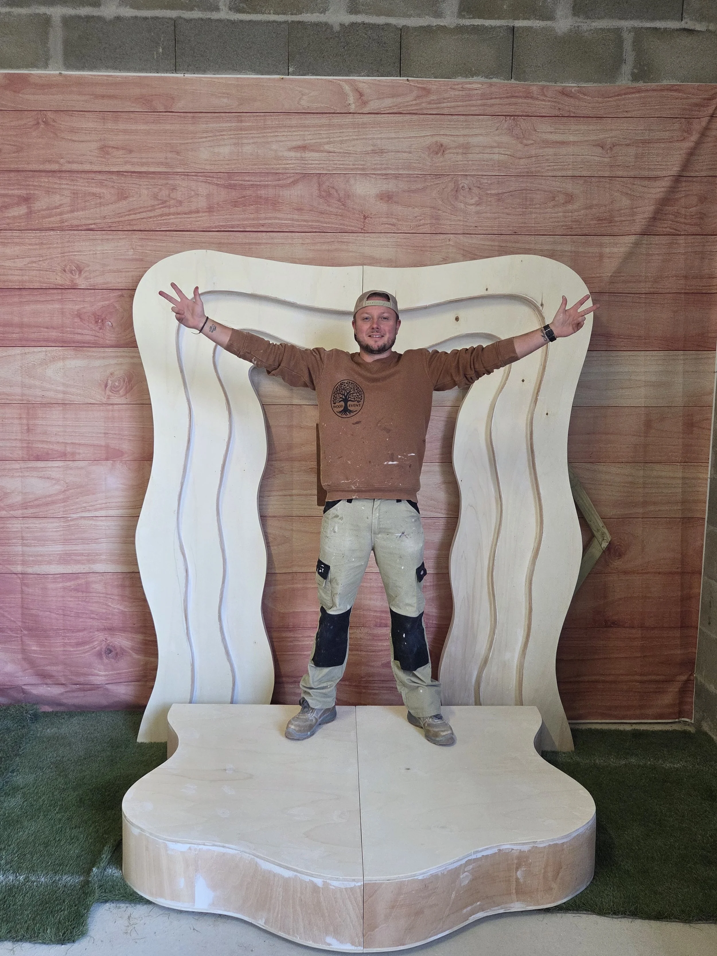 Homme souriant devant une arche en bois artisanale signée Wood Event 33 pour mariage et événements privés