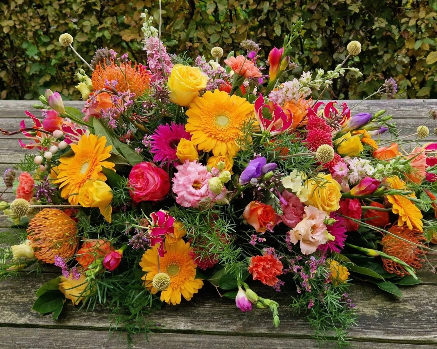 Rouwboeket met warme tinten geel, oranje en roze.jpg