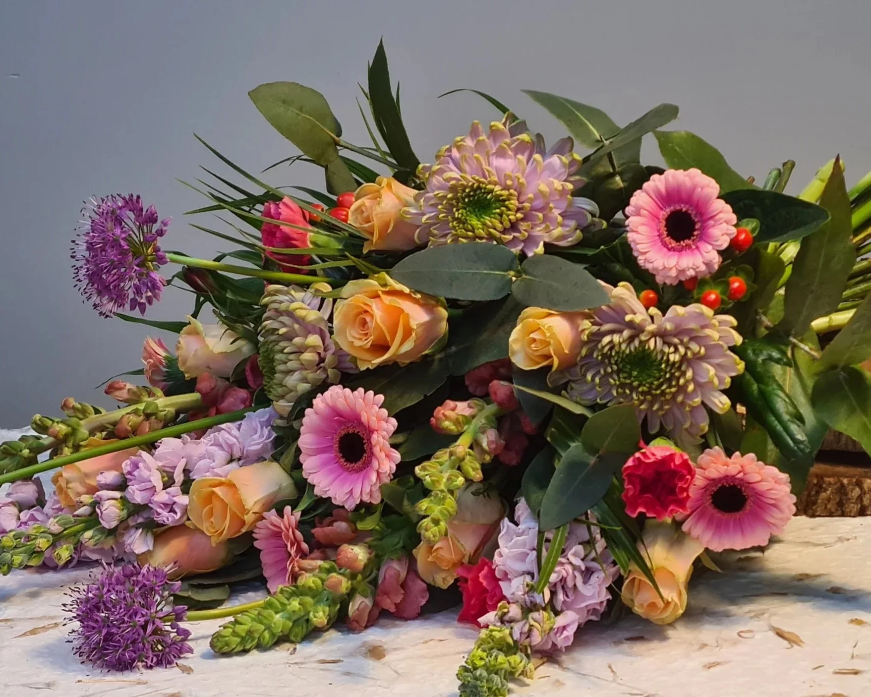 Rouwboeket met roze gerbera’s, rozen en lila bloemen.jpg