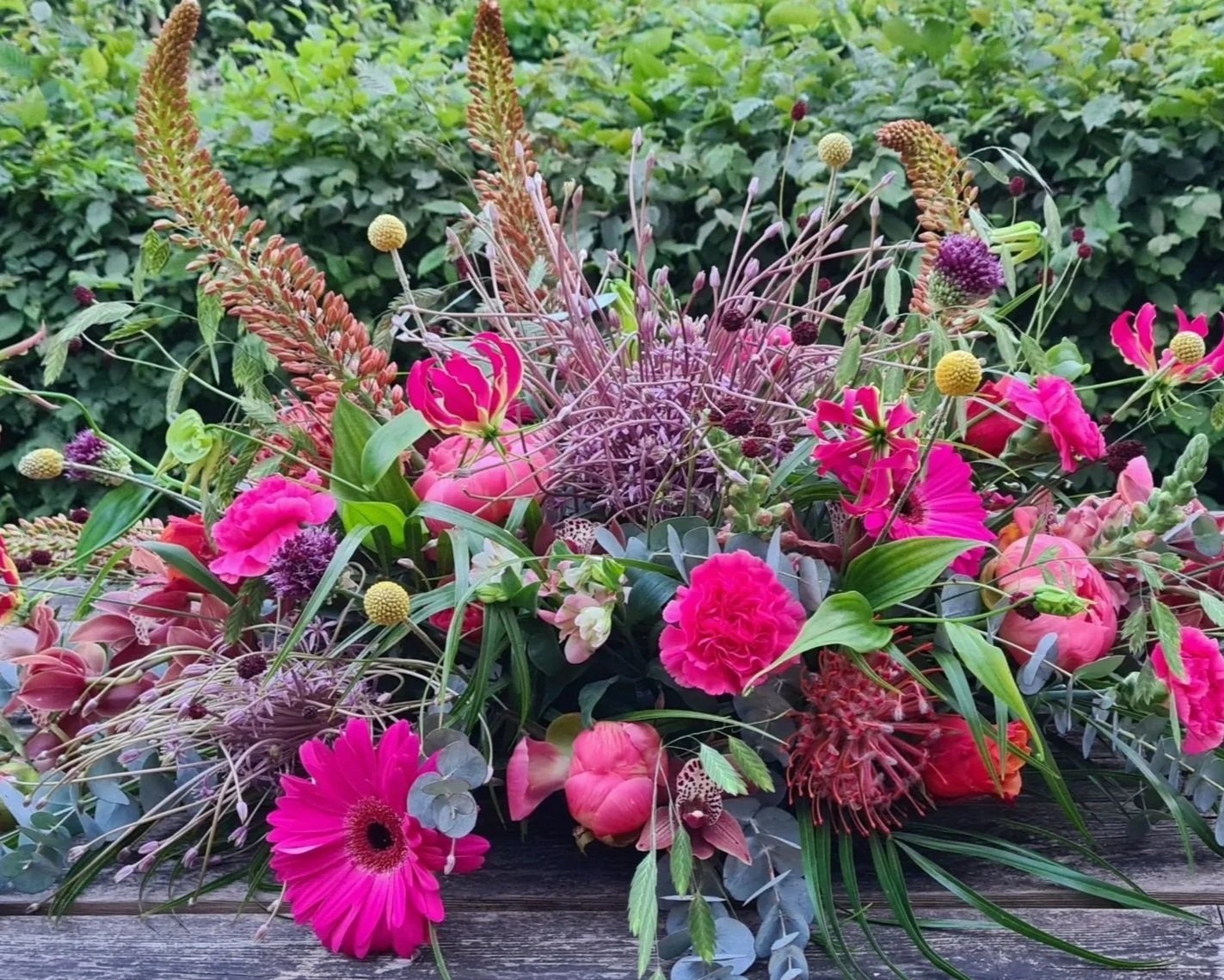 Rouwbloemstuk met roze bloemen en luchtige paarse takken.jpg