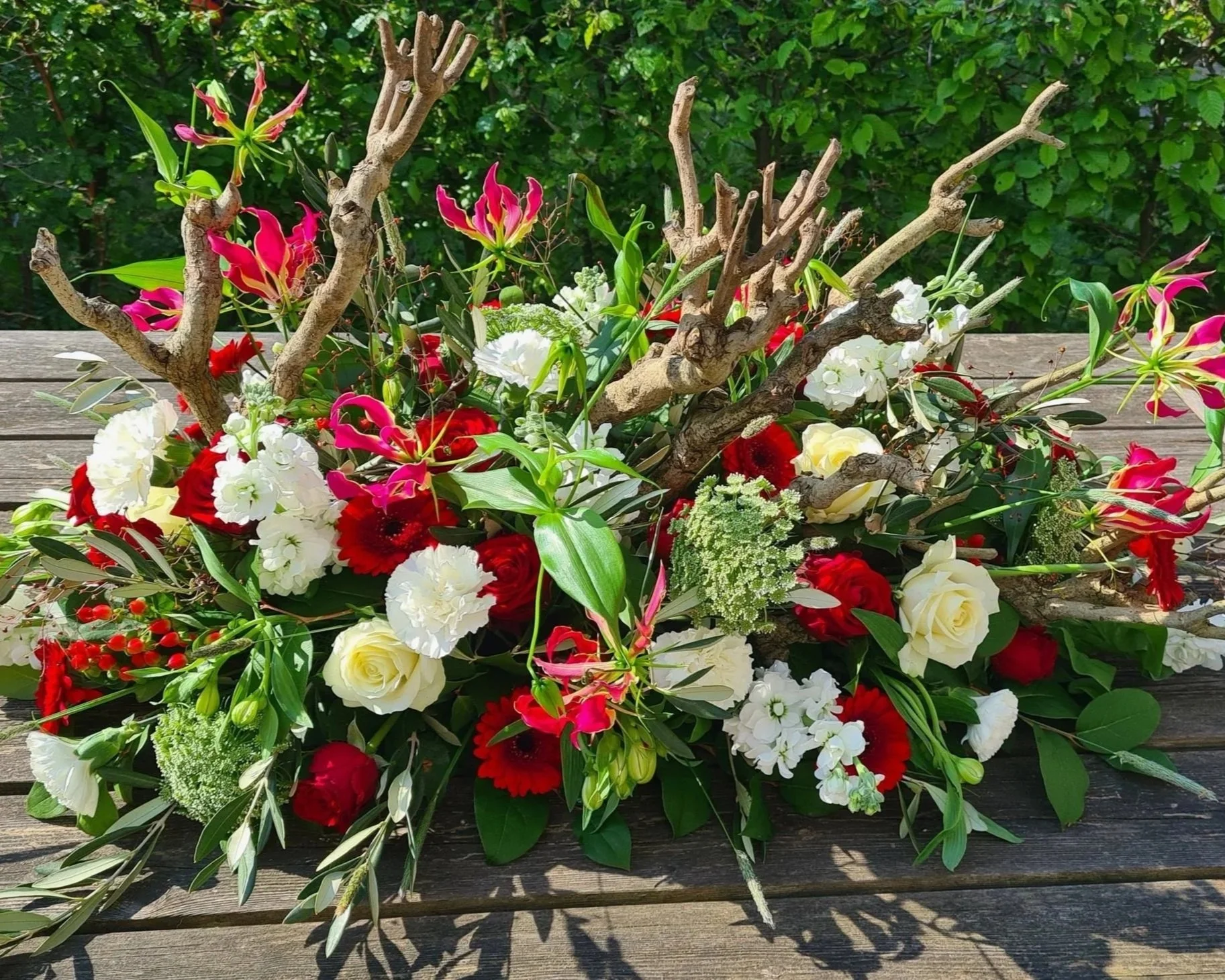 Rouwbloemstuk met takken, rode en witte bloemen.jpg