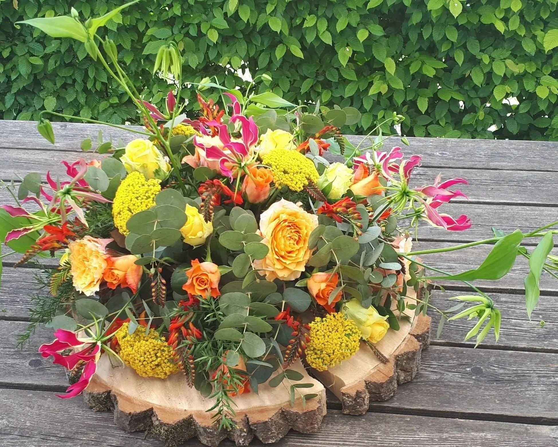 Rouwboeket met gele, oranje en roze bloemen.jpg