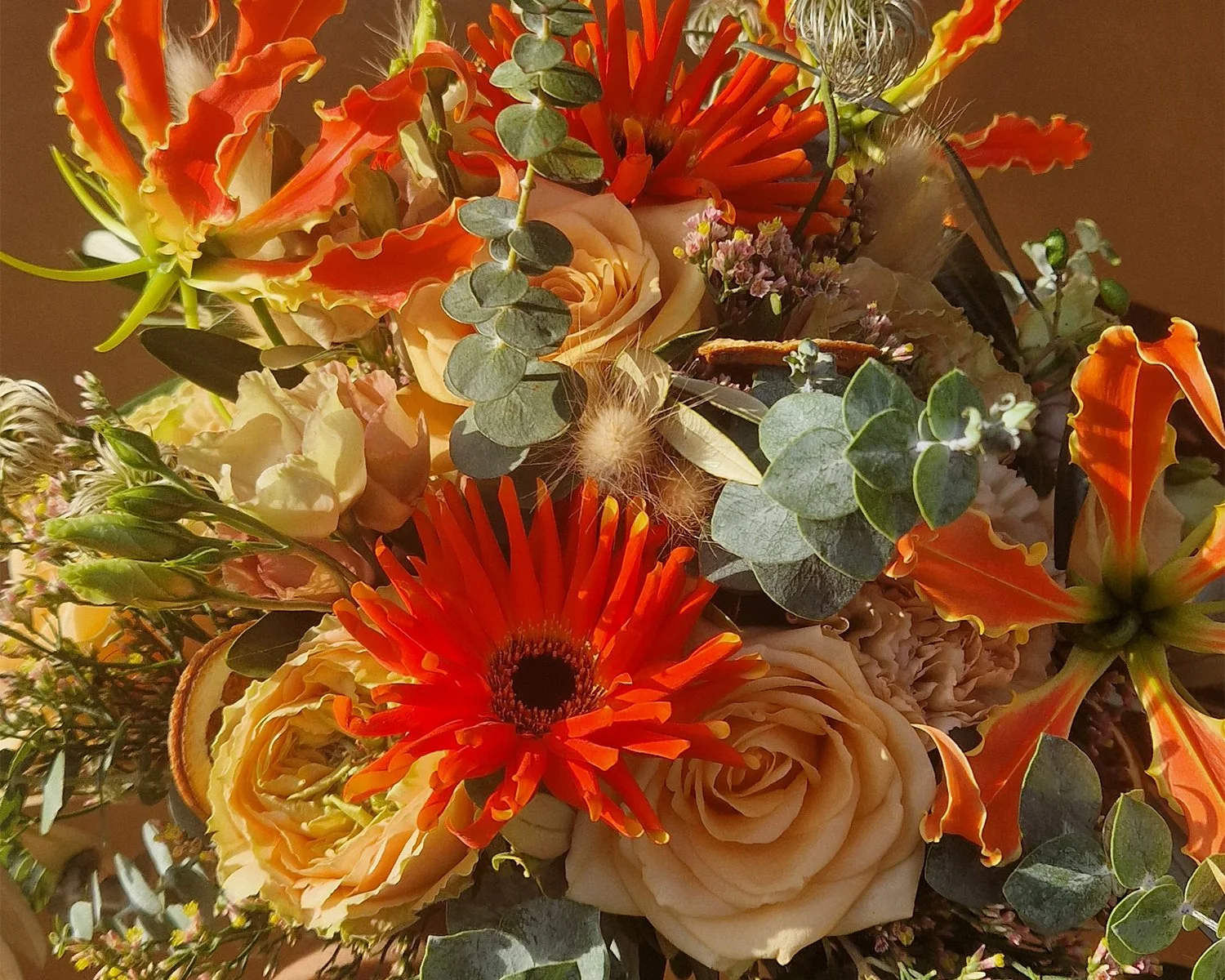 Bruidsboeket met oranje gerbera, rozen en eucalyptus.jpg