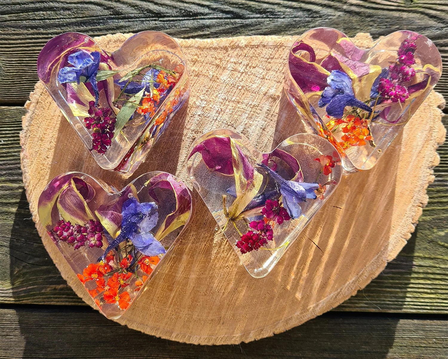 Drie epoxyharten met kleurrijke gedroogde bloemen op hout.jpg