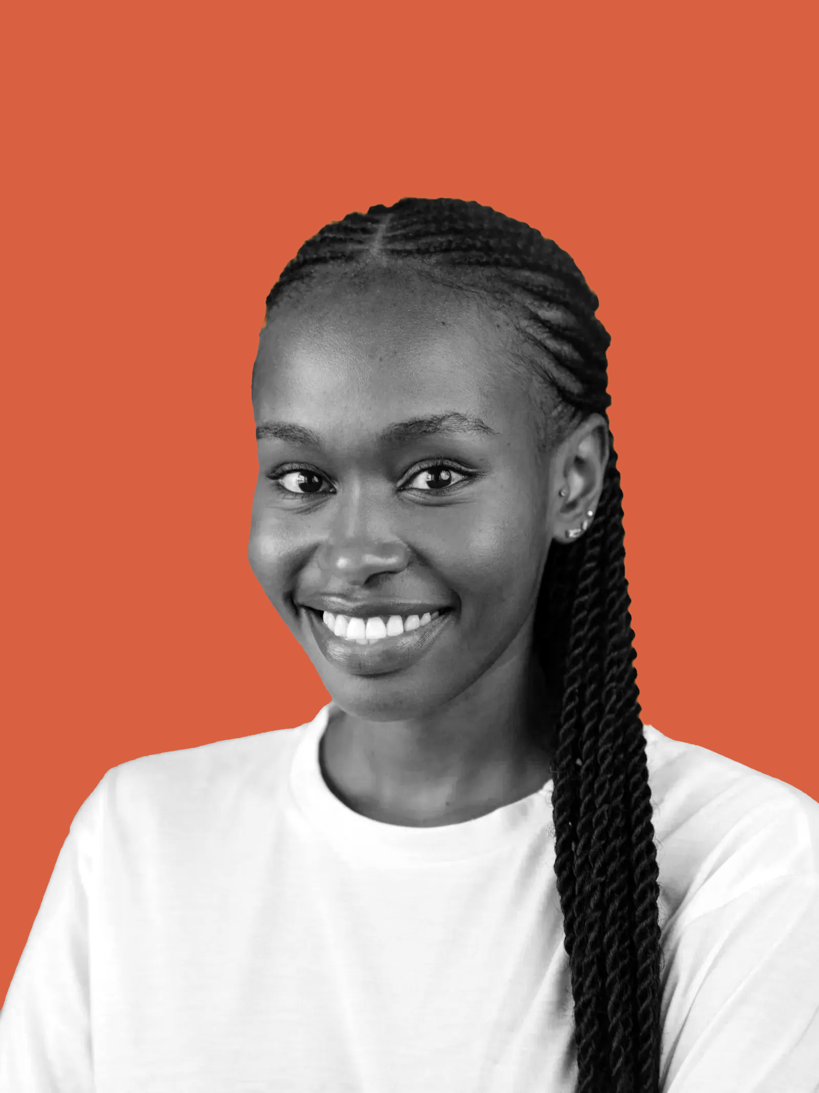 A young woman with braided hair smiling in front of a solid orange background.