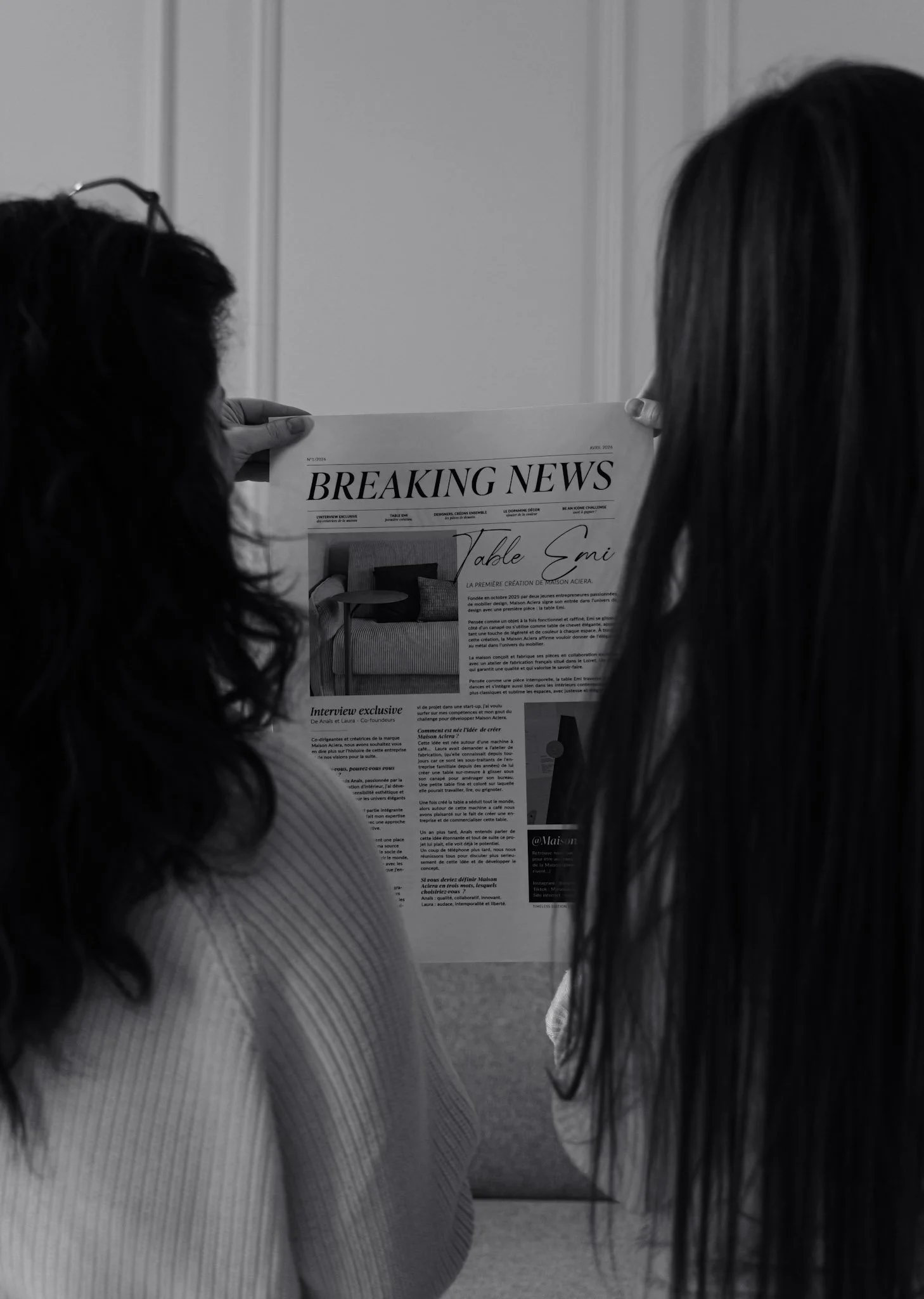 Deux femmes se tiennent face à face, regardant un journal intitulé 'Breaking News'.