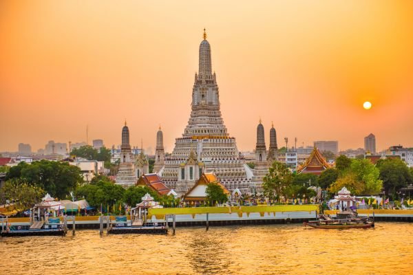 Wat Arun temple along the Chao Phraya River at sunset in Bangkok, Thailand.