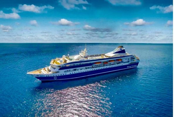 A large cruise ship sailing on the ocean under a partly cloudy sky.