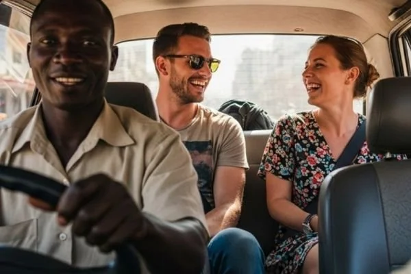 Three people sitting in the back of a car laughing and smiling.
