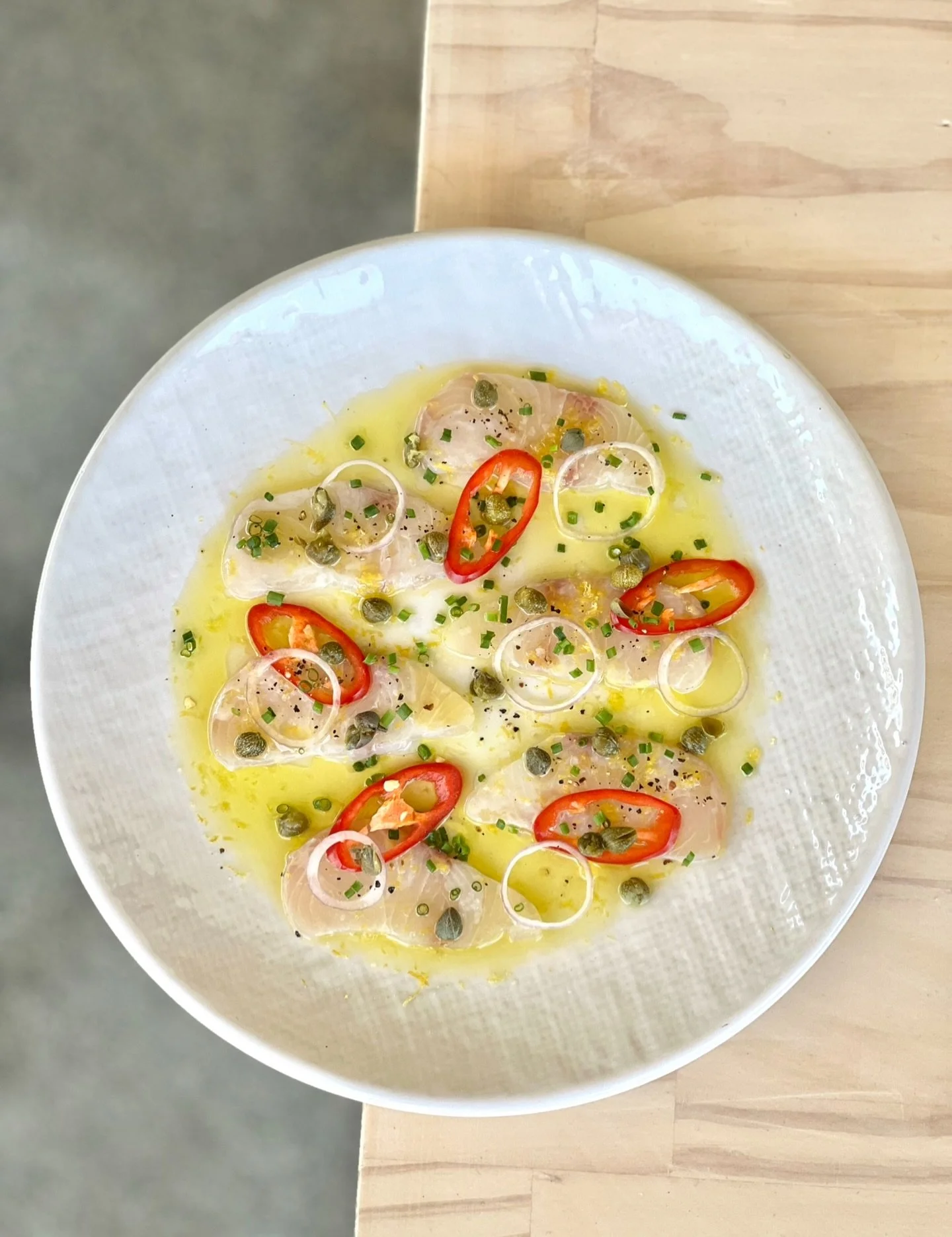Hiramasa Kingfish Crudo 🌶️🍋🫒

A fresh and zesty combination of chilli, lemon, capers and olive oil, complimenting the delicate flavour of Kingfish.