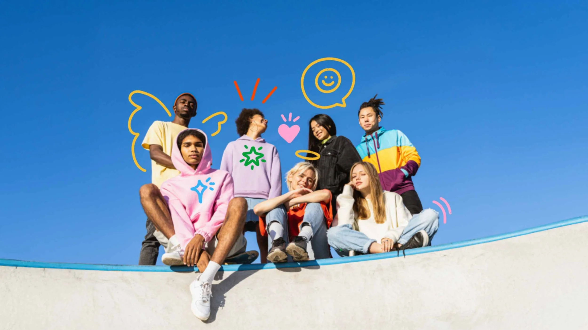 A group of seven diverse young people sitting and standing on a skate ramp under a clear blue sky, with colorful doodle-style drawings of smiling faces, hearts, stars, and expressions overlayed on the image.