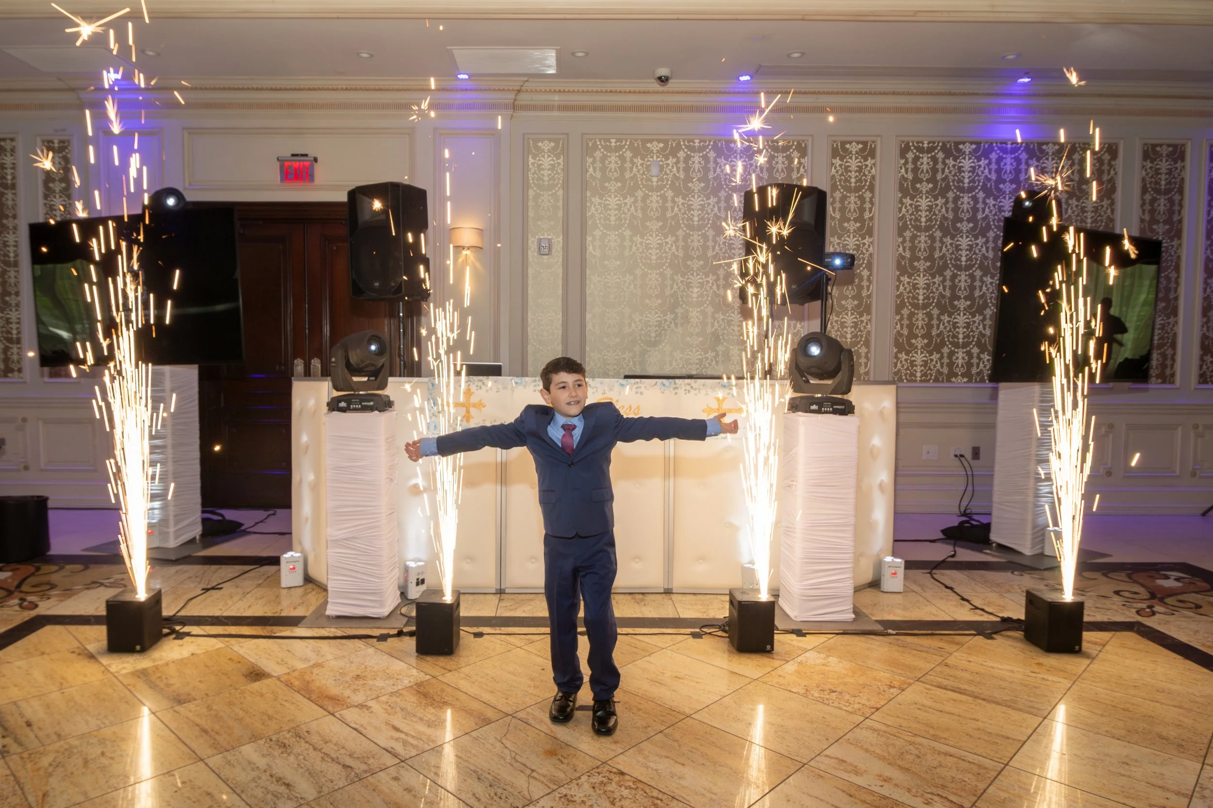 Young boy in a suit celebrating with fireworks display at a party at the Terrace in Paramus NJ.