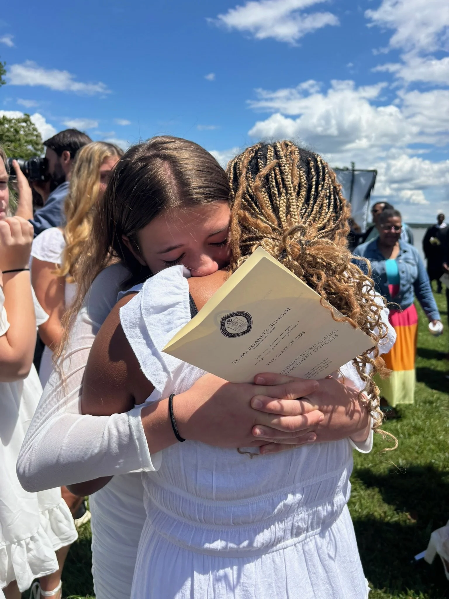 Two SMS students hugging each other at the 2025 graduation with the Rappahannock River in the background.aduation 
