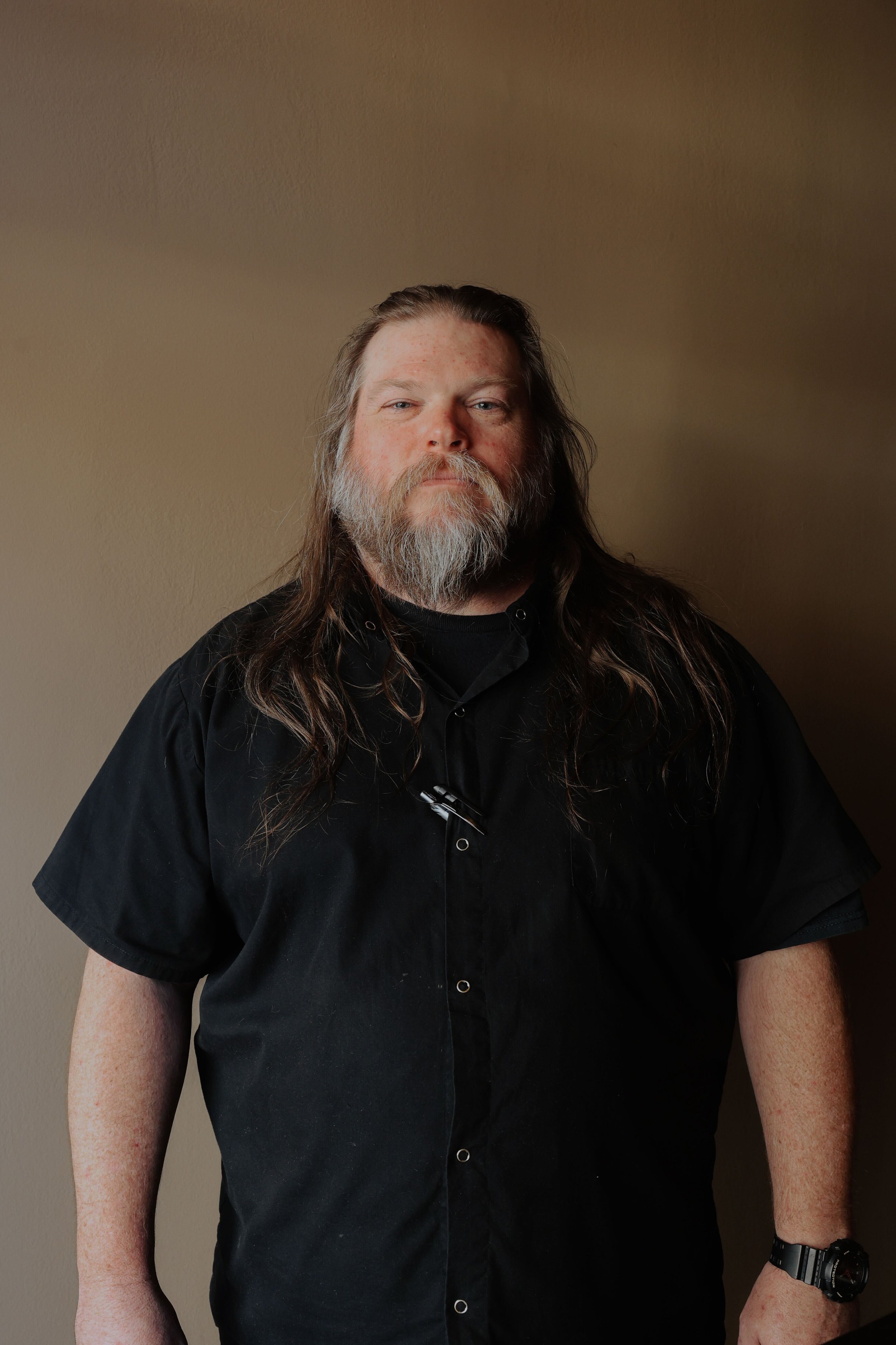 Stack of seven smooth, rounded stones in varying shades of gray and brown on a plain white background.