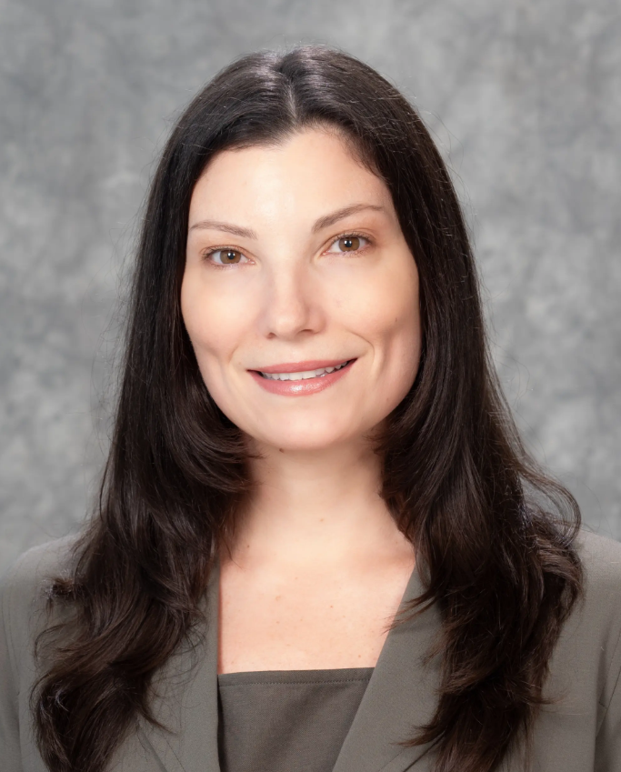 Lisa Valentine from Valentine Mental Health, smiling at the camera against a gray background.