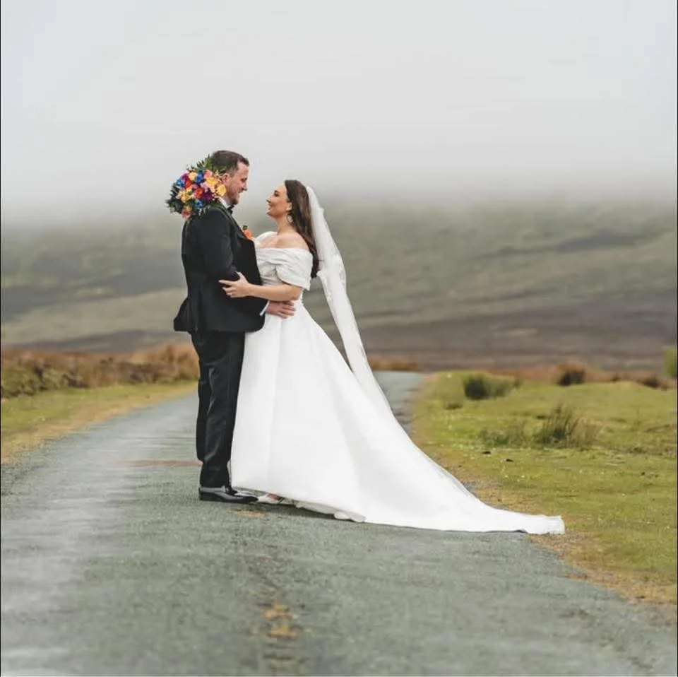 A bride in white dress and her groom in black suit up in the nire valley 