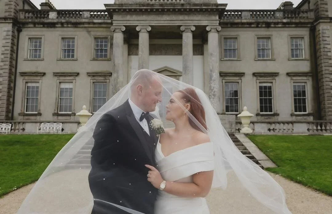 A bride in her white dress with husband beneath her pearl veil at the heritage hotel killenard 
