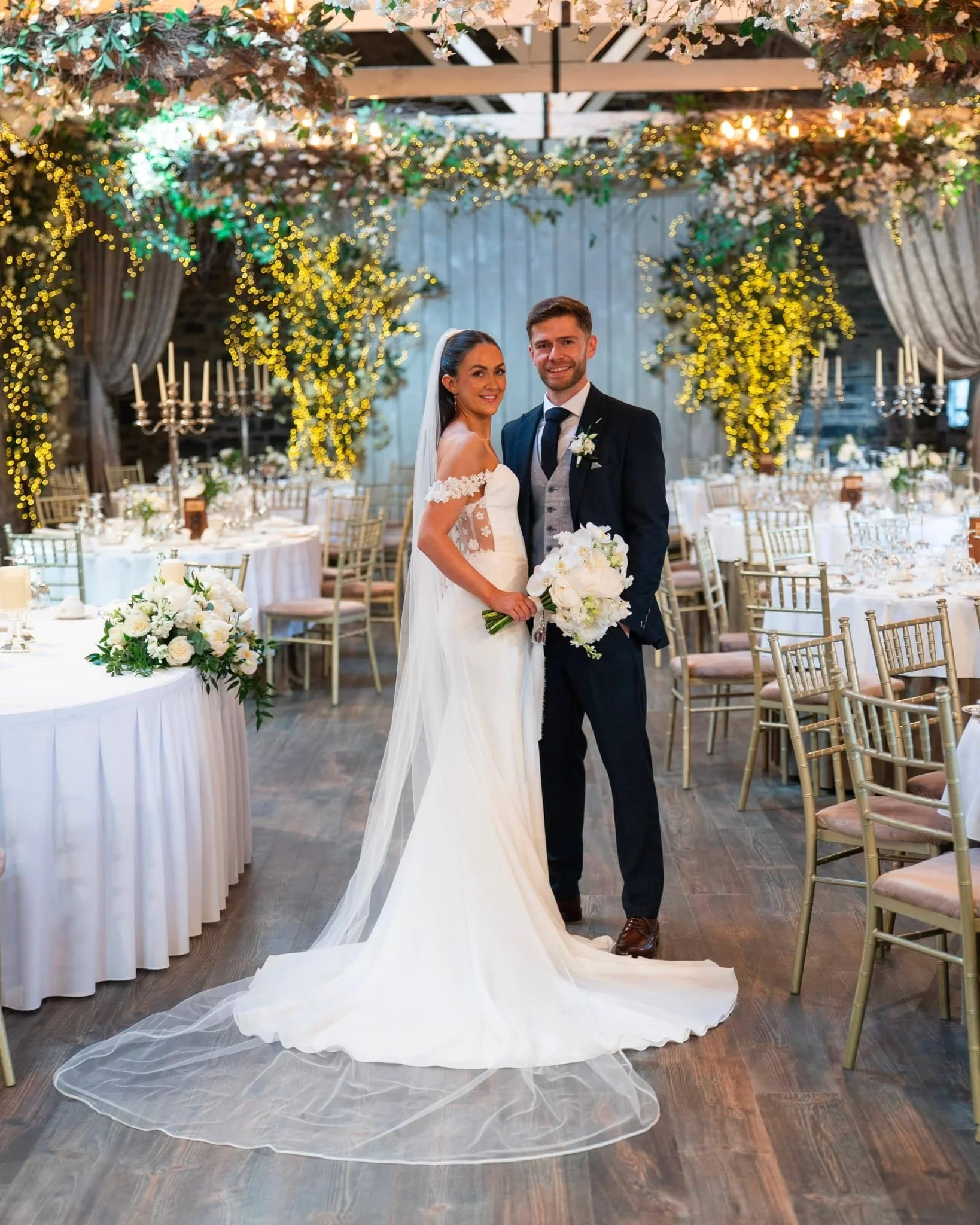 A Bride and her new husband in her beautiful  Mikaella gown holding white bouquet at Mount Juliet 