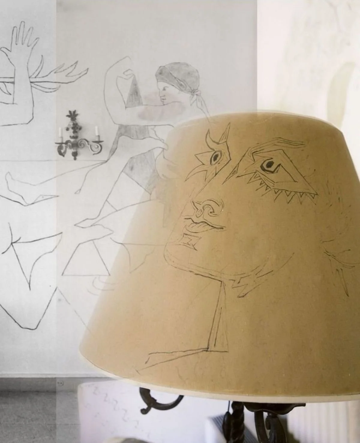 Sketches of a woman reading a book, a hand holding a paper, a candle sconce, and the face of a mythical creature on a lamp shade.