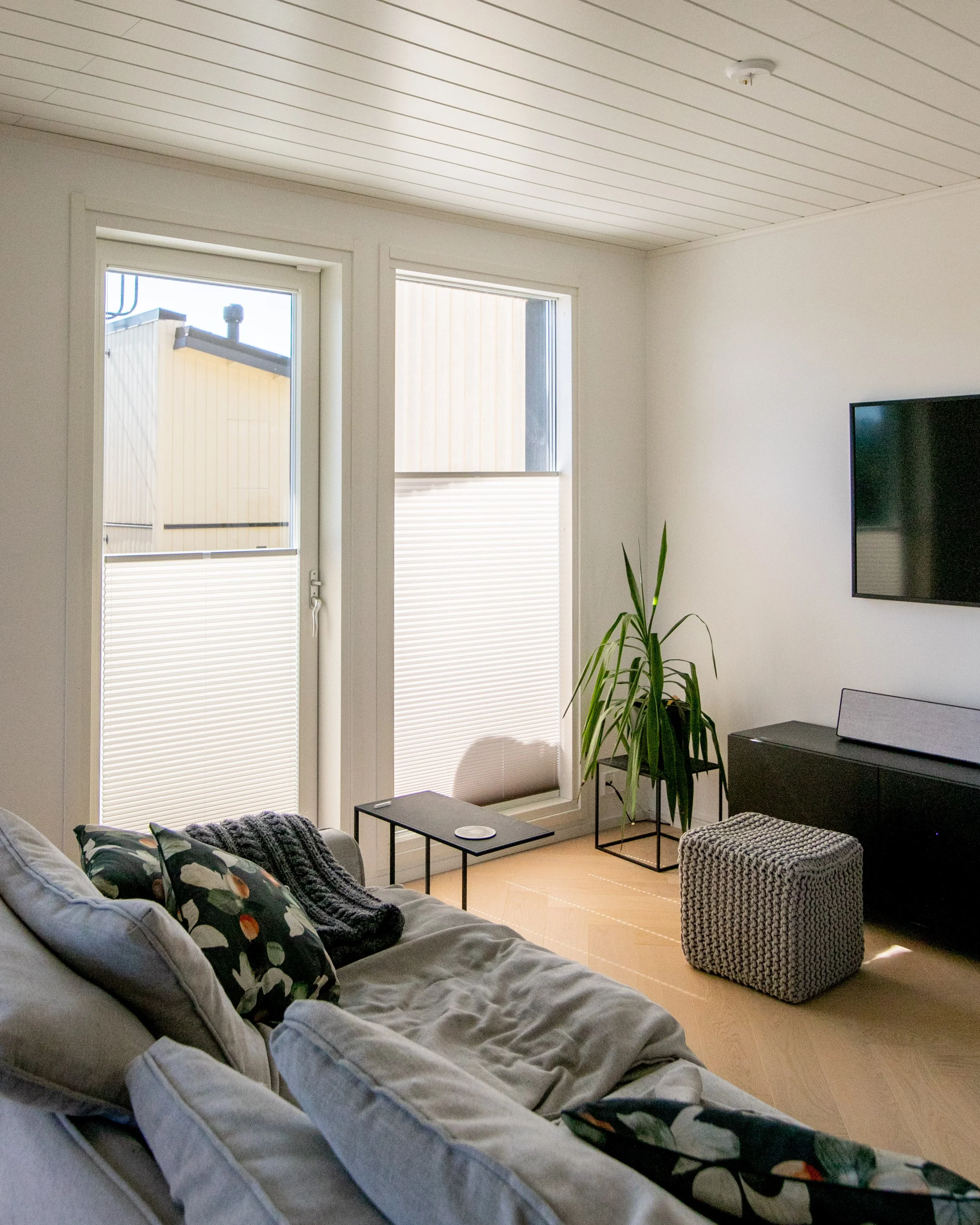 Keittiön sisustus ikkunalla, joka on varustettu kaihtimilla ja pienen kasviastiat seinäkuvaskaiteella, sekä matto lattialla.