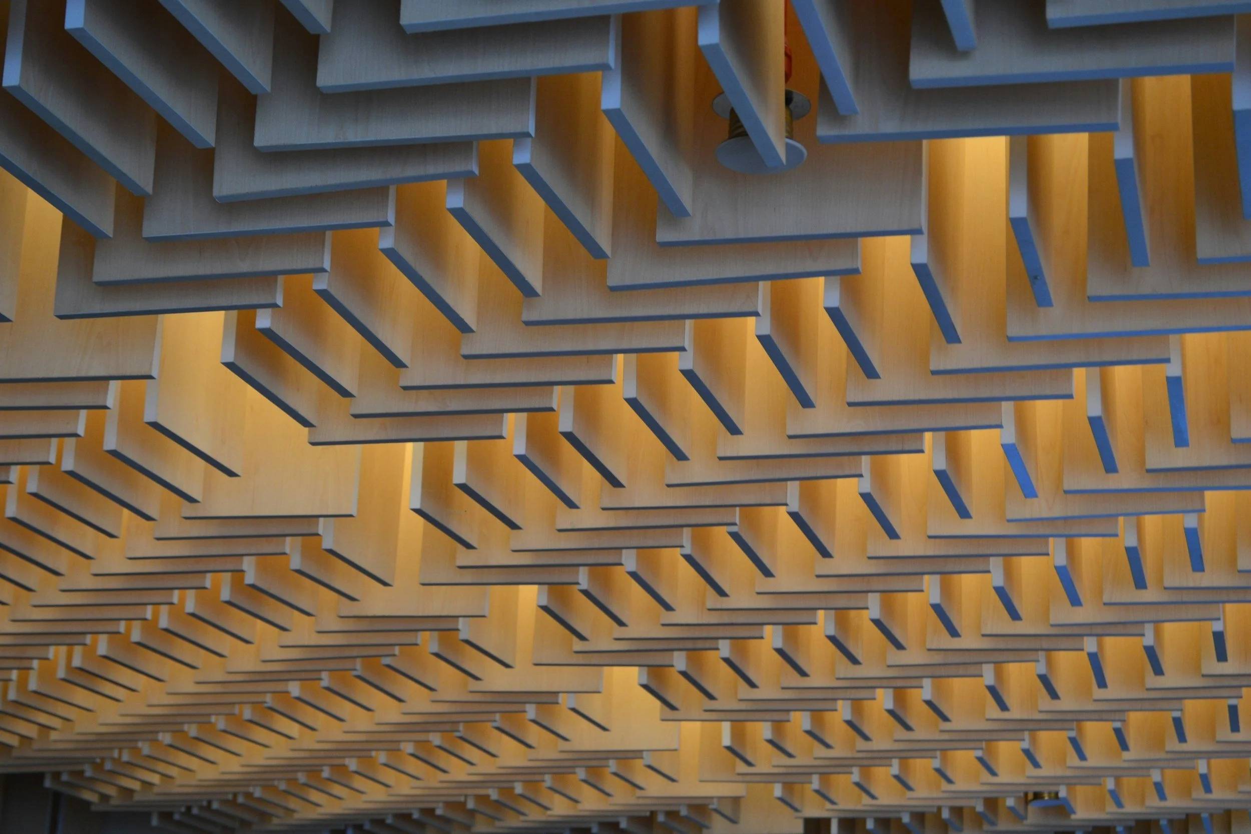 Wood acoustic baffles hanging from a ceiling