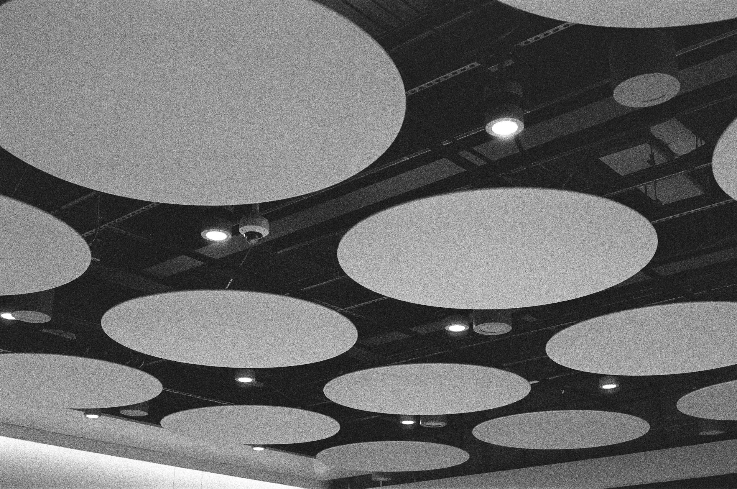Round acoustic clouds suspended below a ceiling