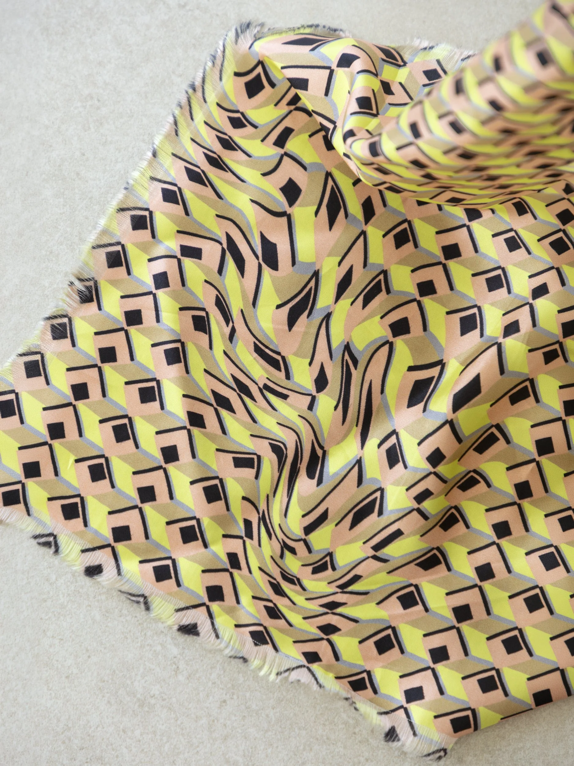 Detail van Geneviève sjaal met geometrisch patroon dat naar de hoeken vervormt