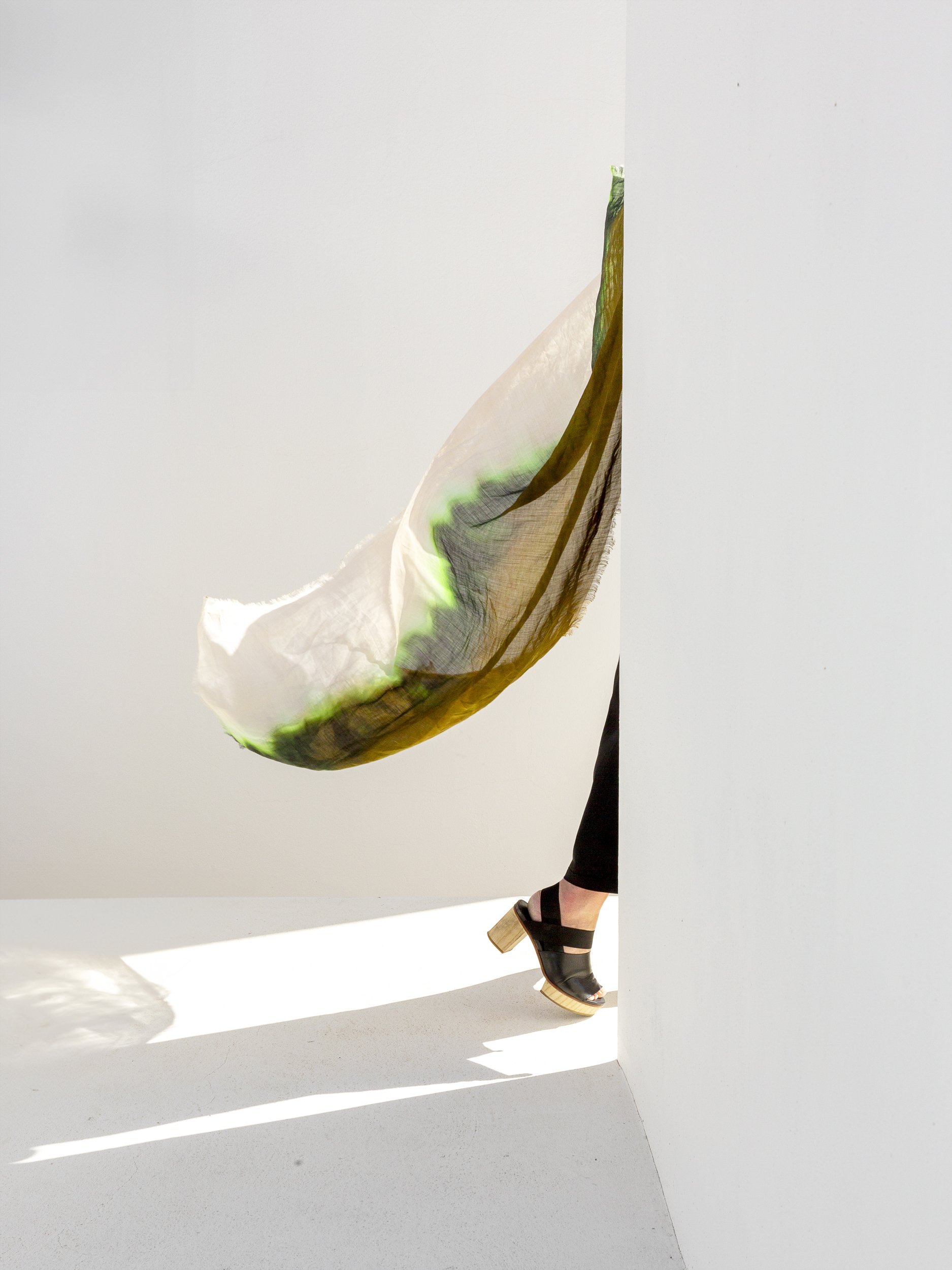 vrouw draagt de Nina sjaal van Sklpt.  Een slowfashion sjaal gemaakt van ramie.