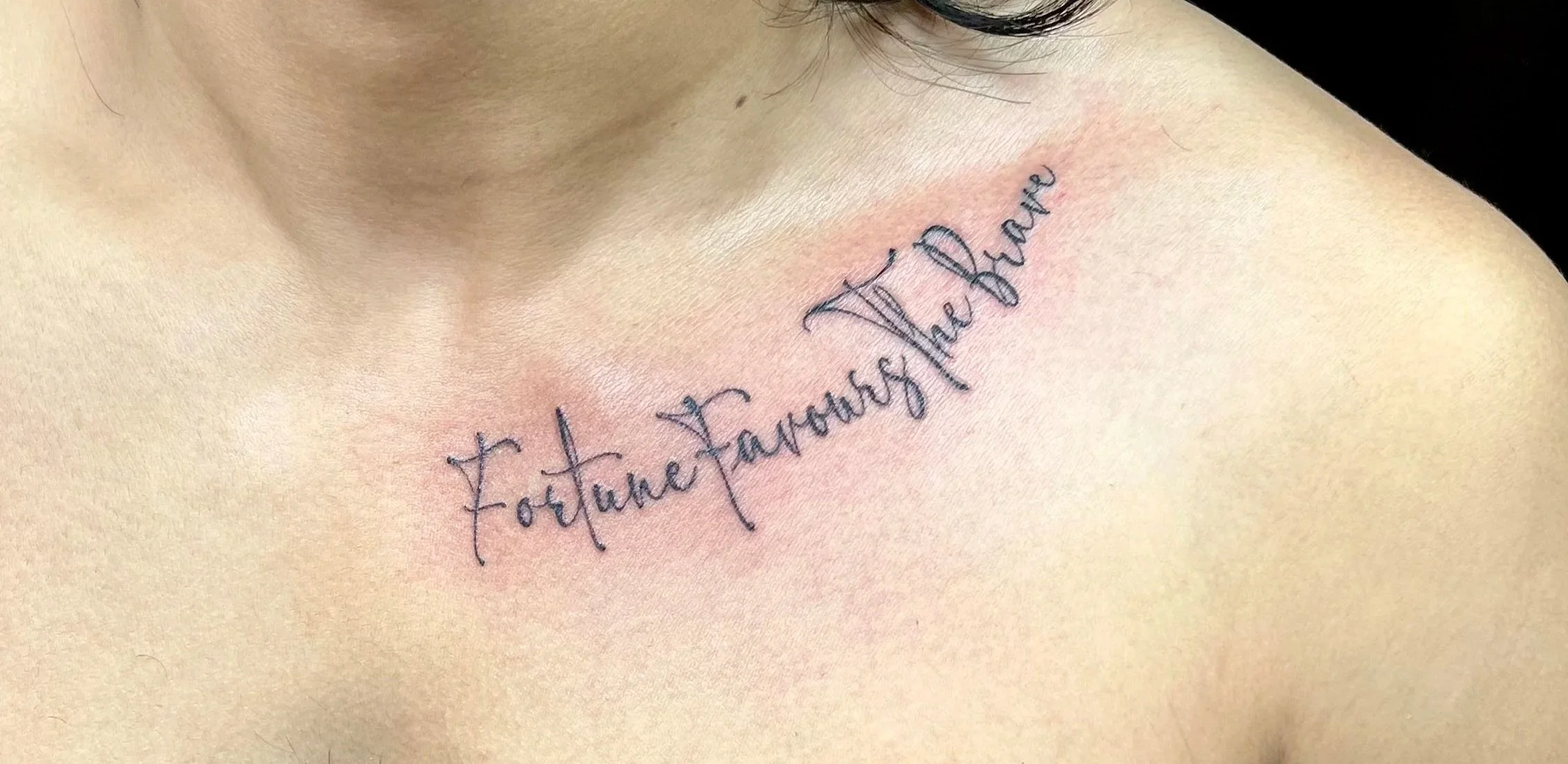 Delicate fineline script tattoo on the collarbone