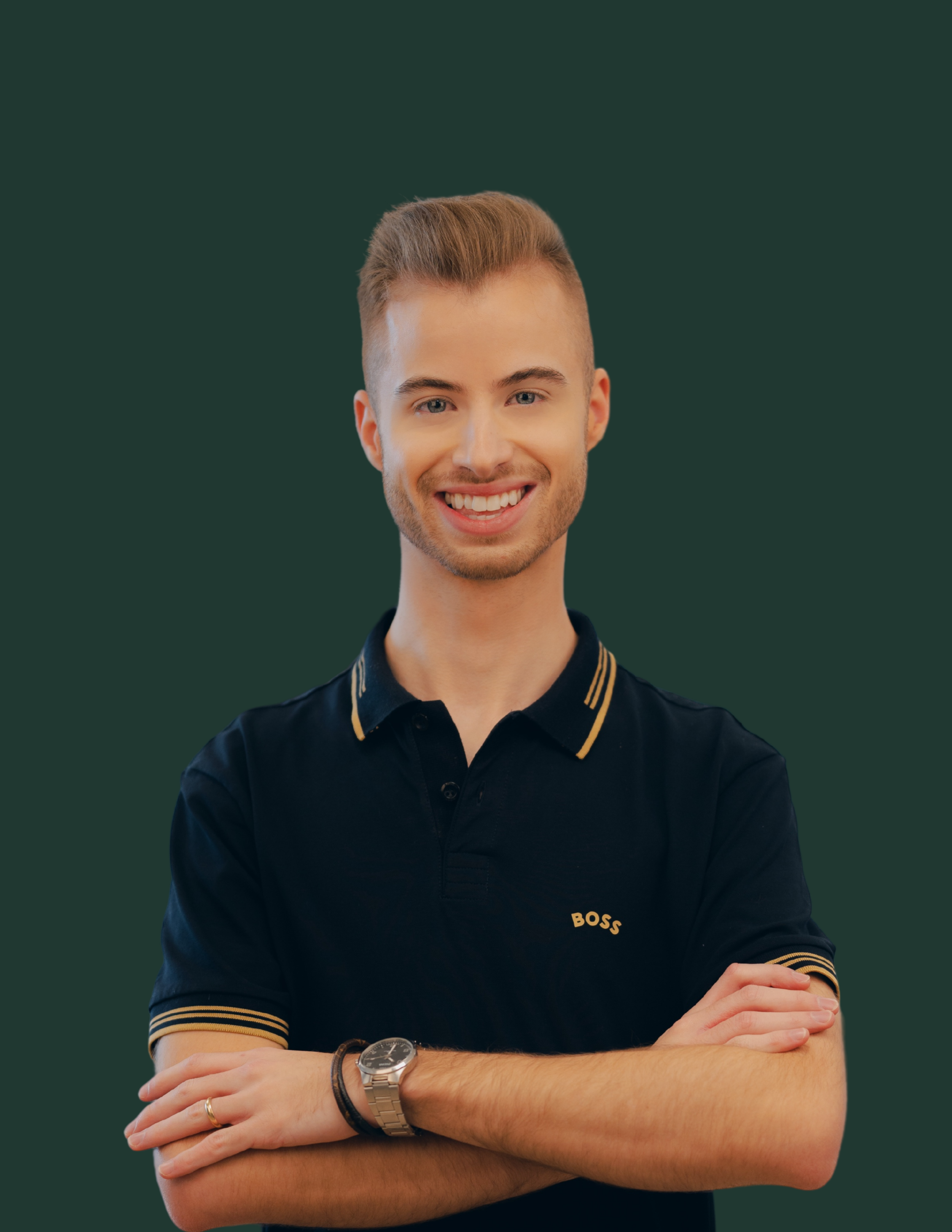 Jeune homme souriant avec des bras croisés portant un Polo noir avec le mot 'BOSS' sur la poitrine, contre un fond vert.