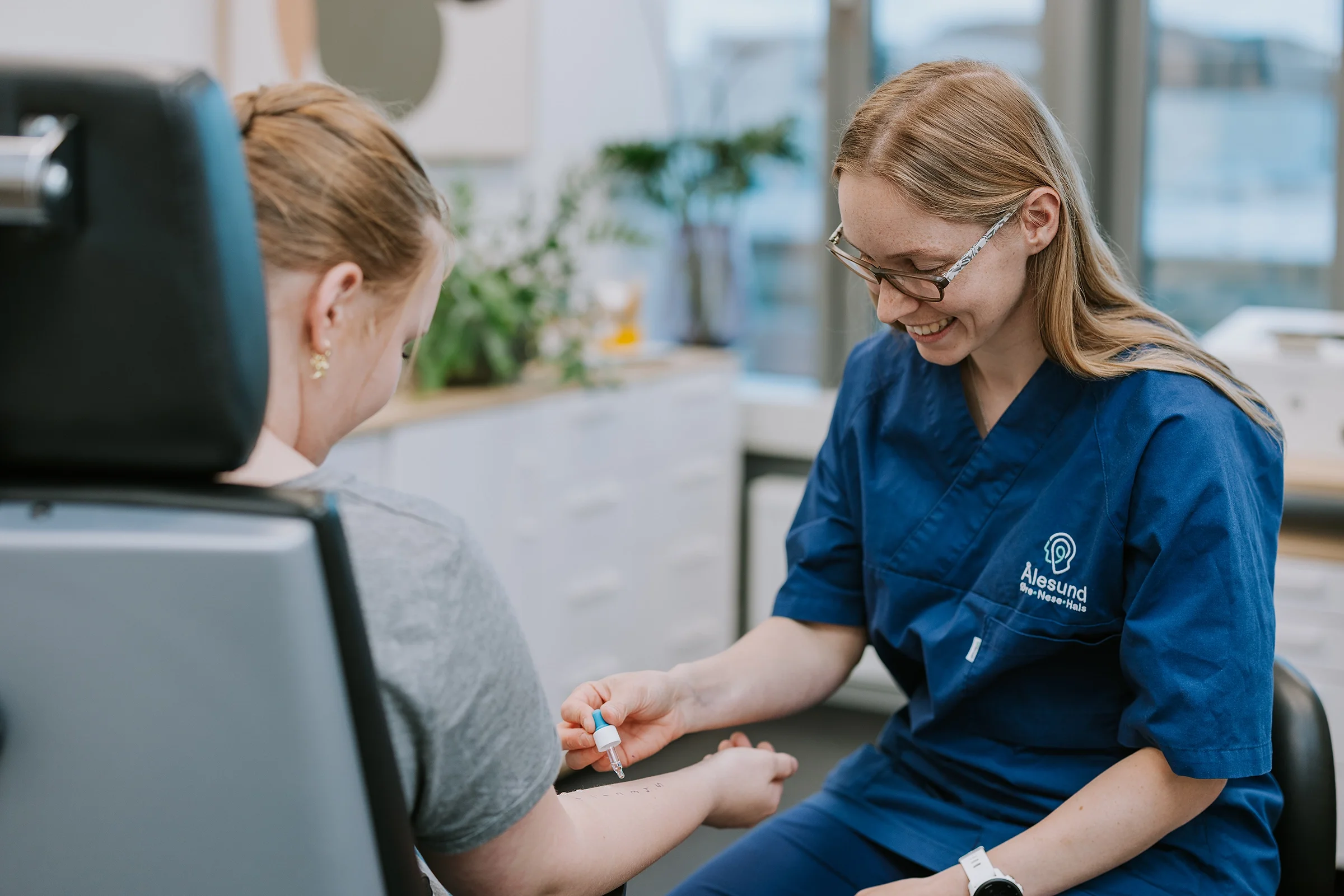 En medisinsk person i blå uniform som gir en injeksjon til en pasient i en klinikk eller sykehus.