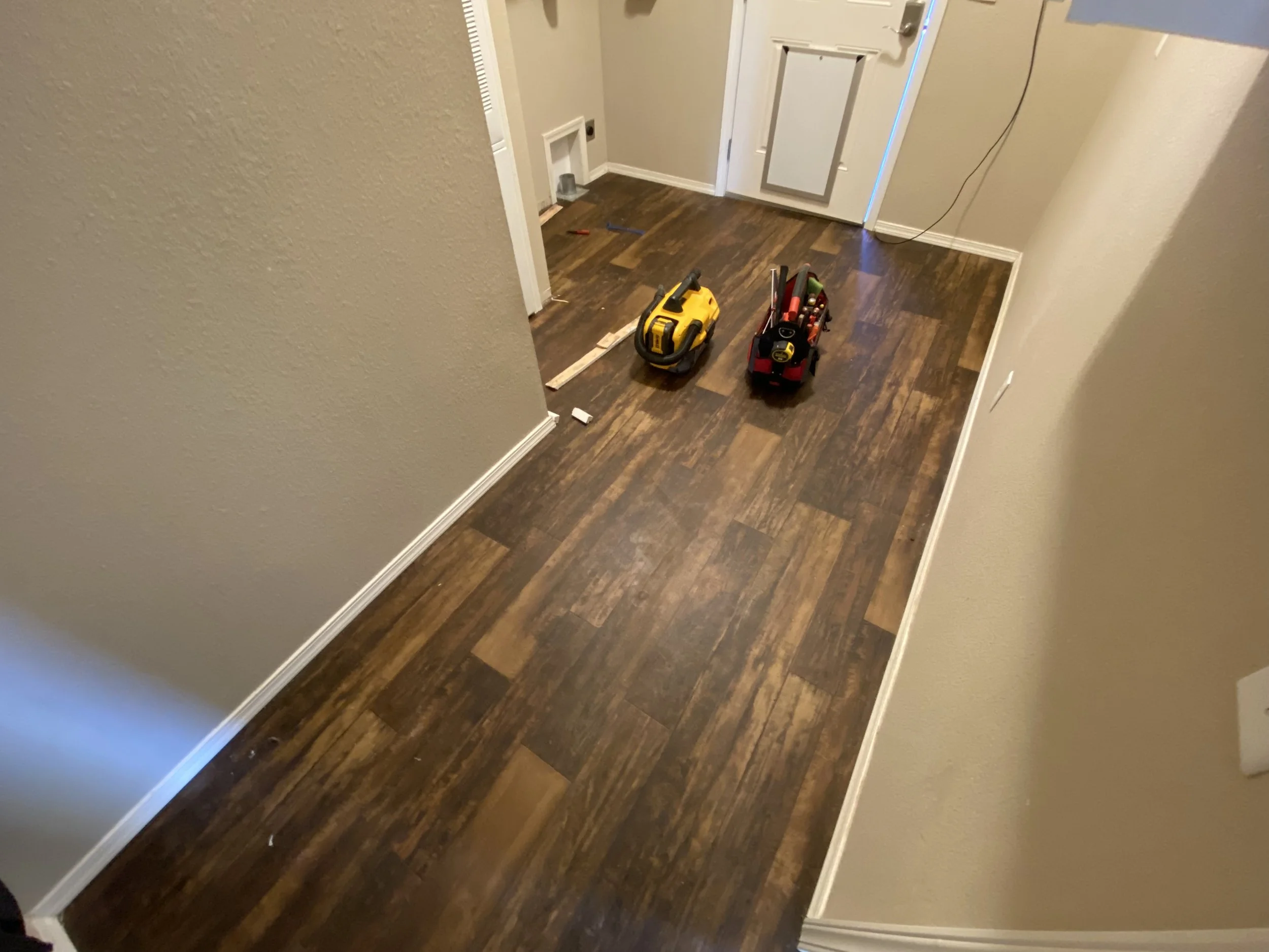 Costumer wants new flooring and base trim to make the laundry room match the rest of the house (This is the old floor and base trim)