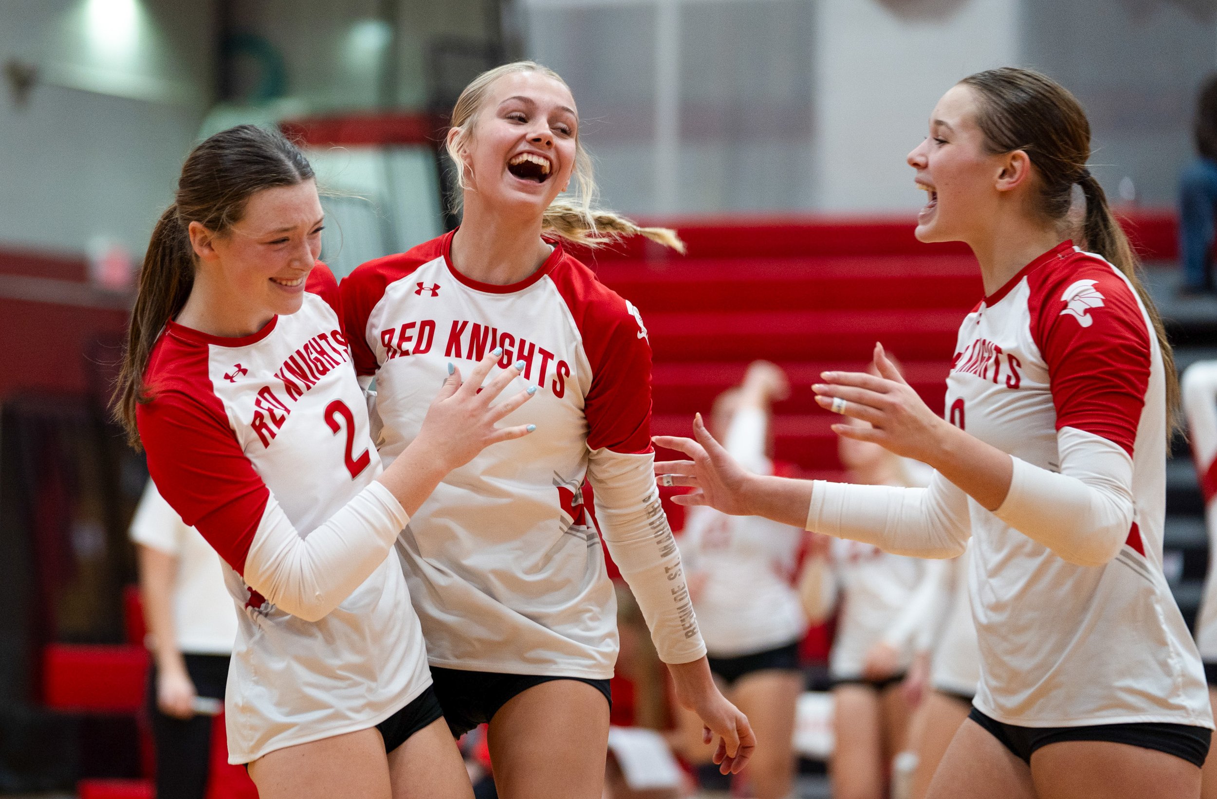 Sydney Friedly, Sela Lynk and Avery Minor of the Benilde-St. Margaret's Red Knights celebrate after hitting a successful spike against the Orono Spartans during the Section 6AAA volleyball game at Benilde-St. Margaret's High School in St. Louis Park,