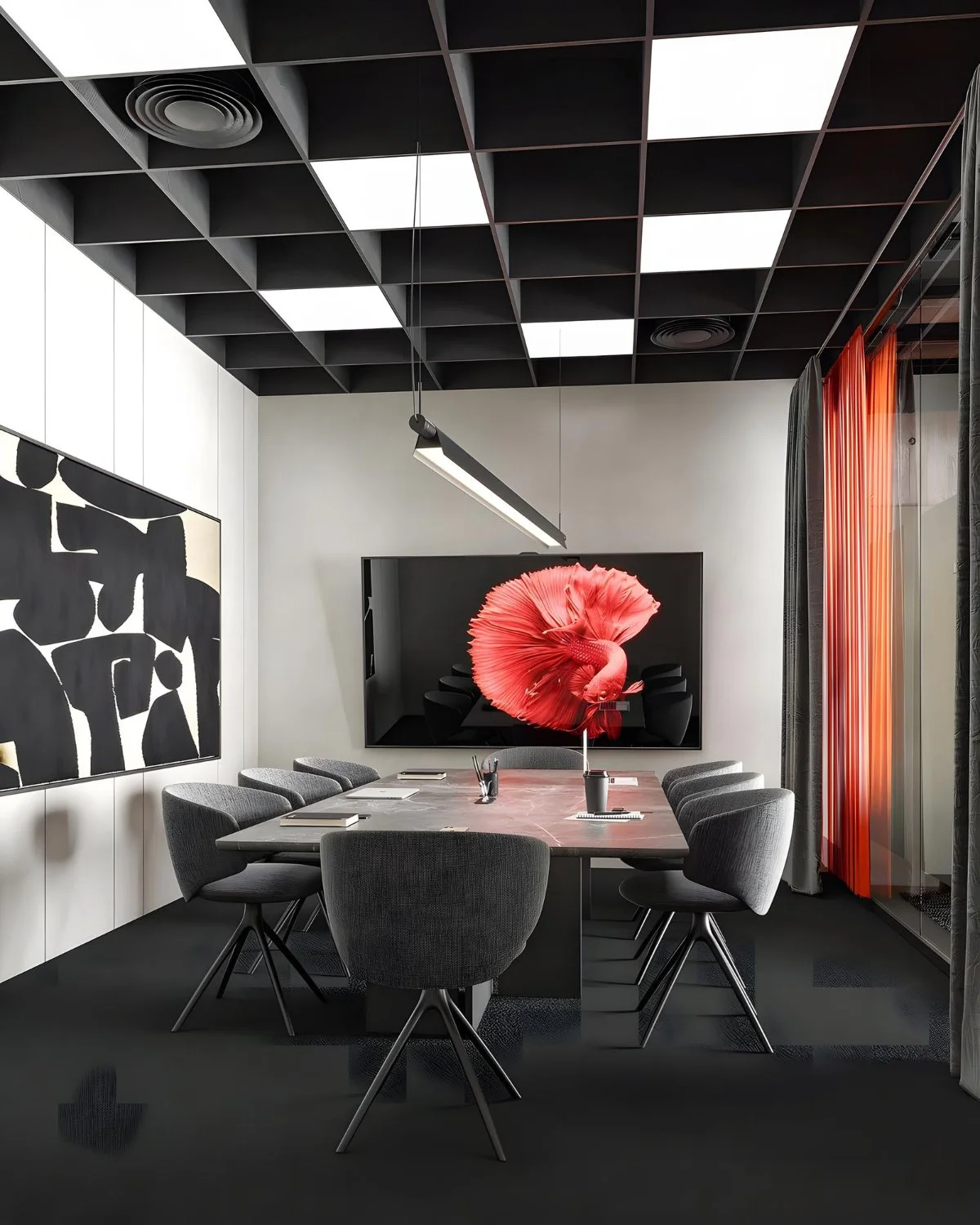 Sala de reuniones con mesa rectangular, ocho sillas grises, una pantalla grande con una imagen de un pez tropical rojo, decoración moderna con cuadrosabstractos y cortinas grises y naranjas.