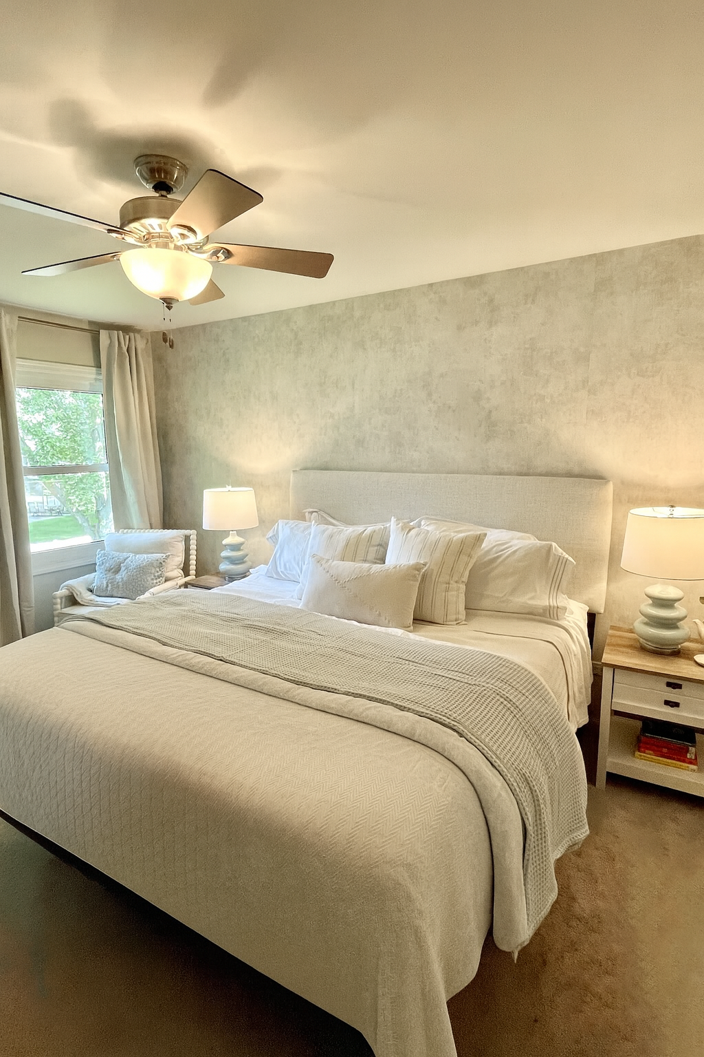 These busy working parents needed an overhaul in their primary bedroom. I rearranged the flow of the room to give them each a nightstand, created a peaceful reading nook by the window, brightened up the bedding, and added to the serenity of the room'