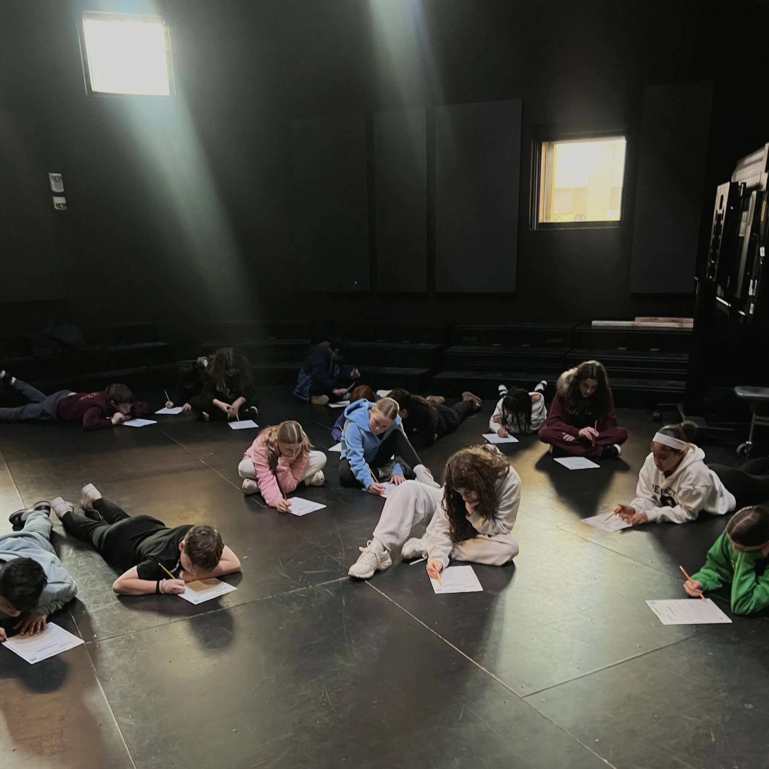 Children playing outdoors at a playground with sunlight shining behind them.