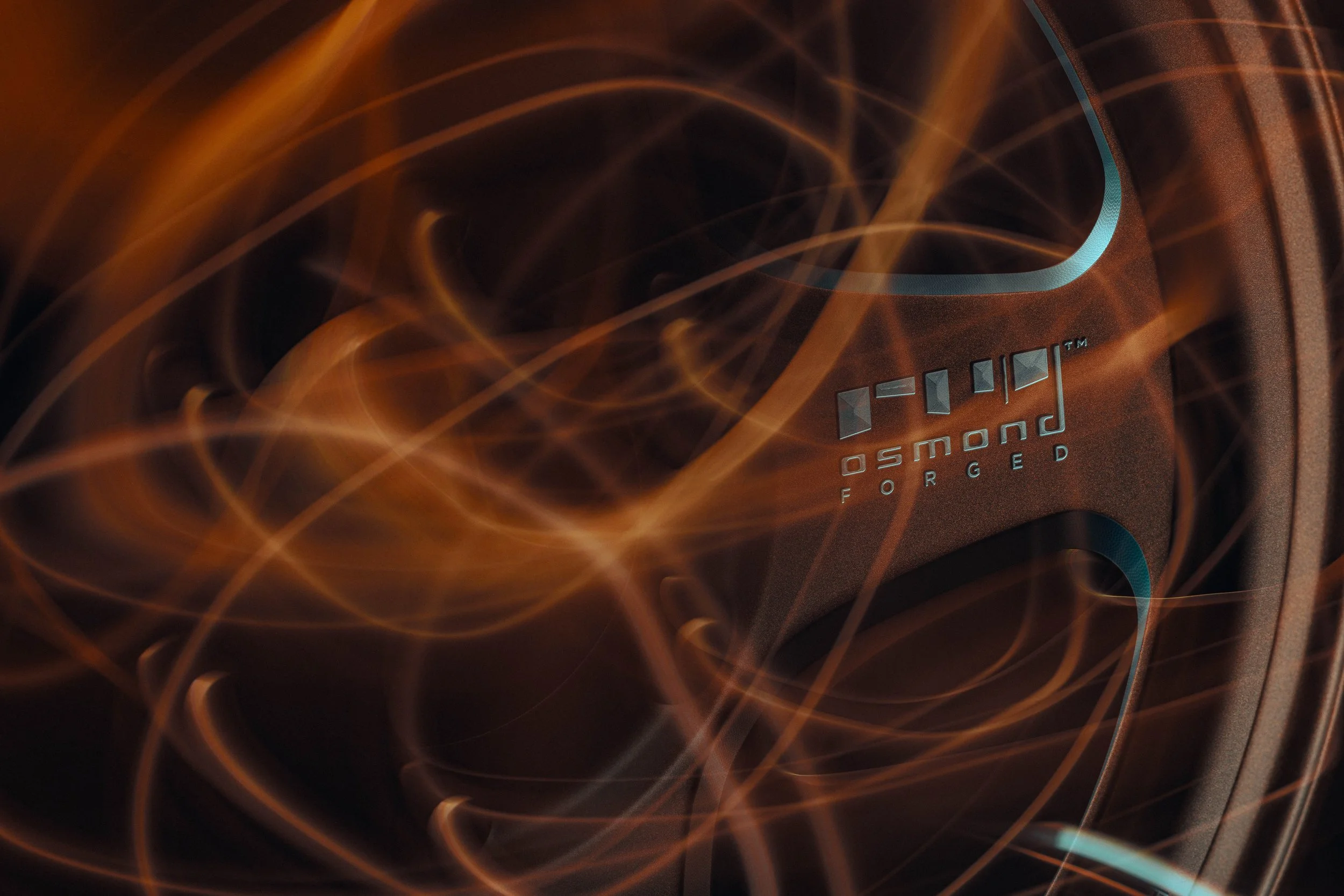 Close-up of a speaker with glowing orange and blue light trails and the text 'OSMOND FORGED' on it.