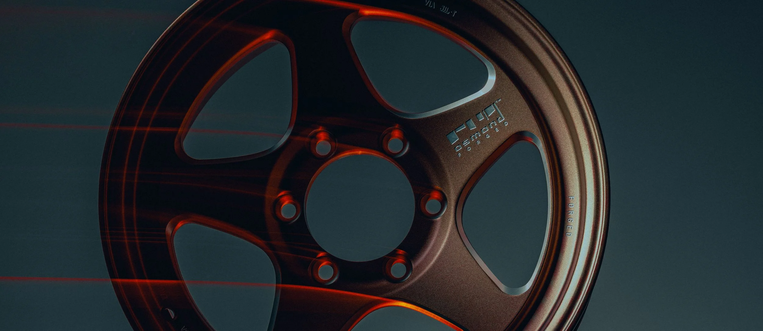 Close-up of a machine part with a metallic finish, featuring cutouts and stamped text, illuminated with red lighting.
