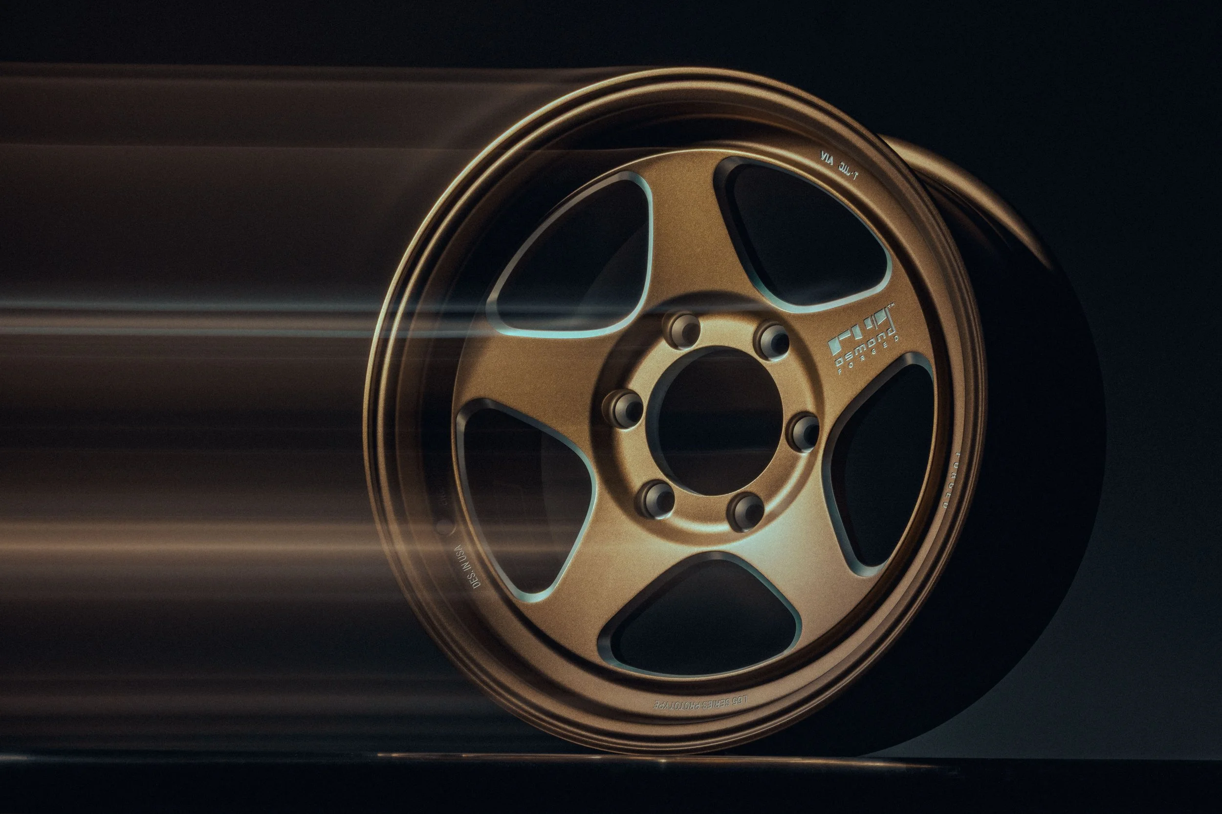 Close-up of a gold colored wheel rim with a black background and blur motion streaks.