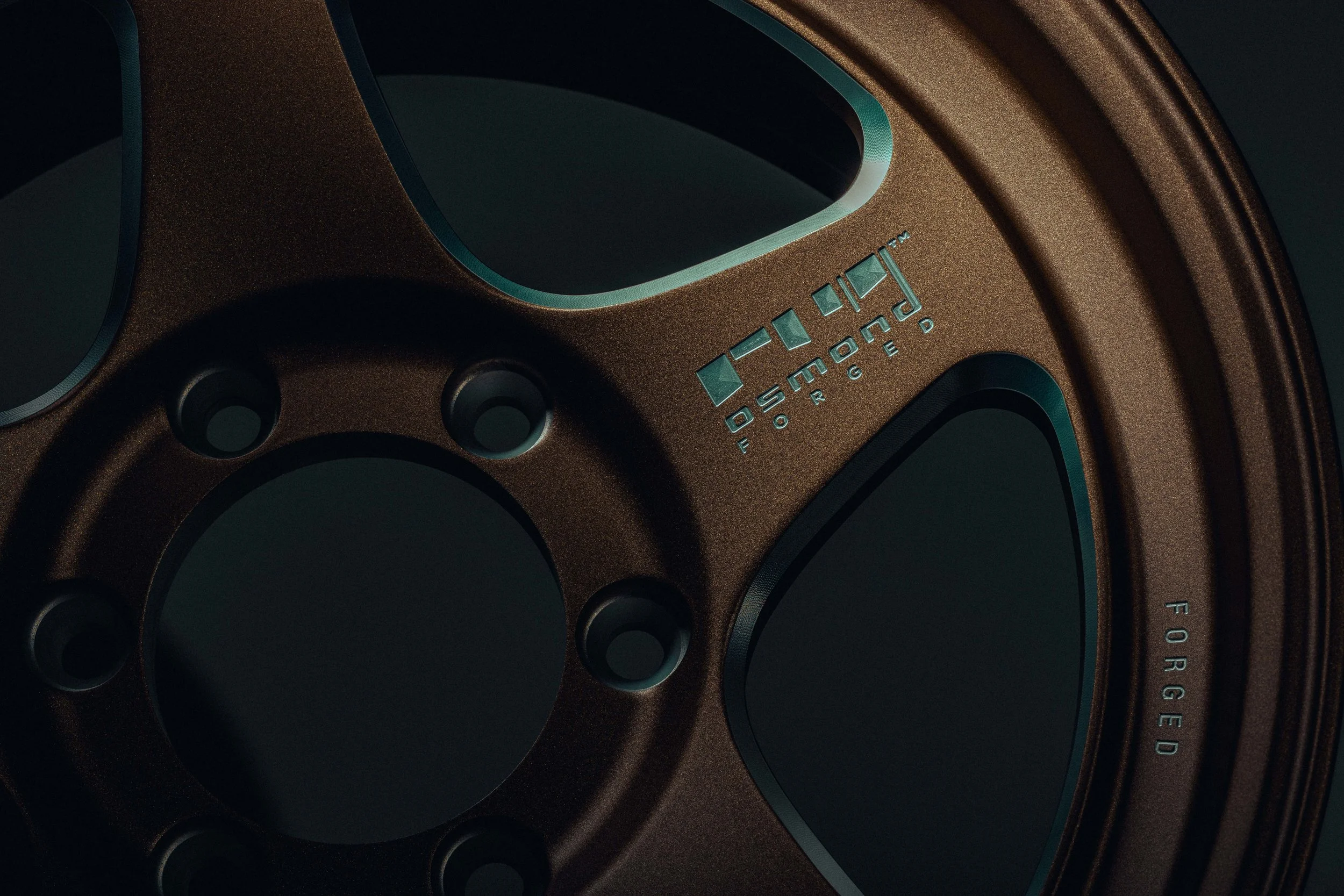 Close-up of a brown speaker with the brand name 'Osmond' and the word 'ORGANIZED' on it, showing part of the speaker's circular design and controls.