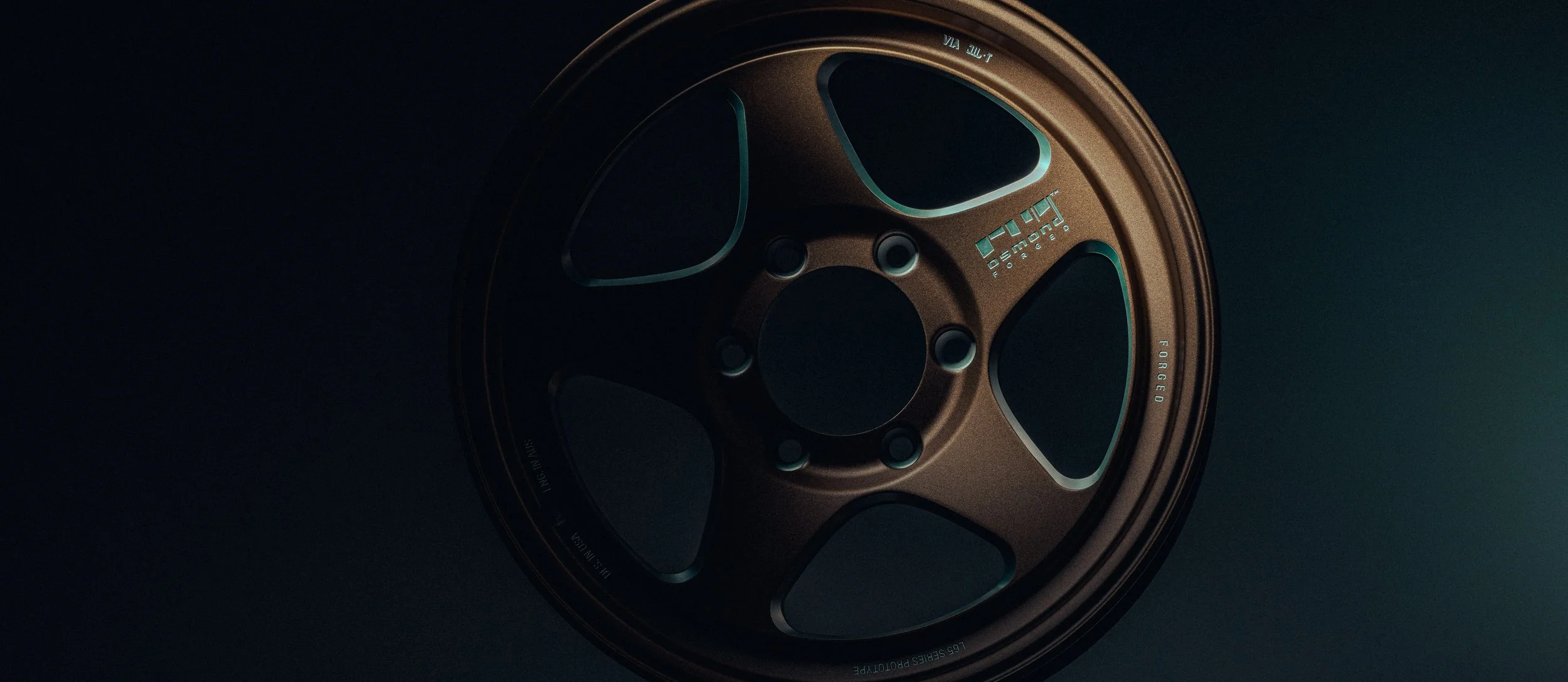 A metallic disc wheel, likely for a vehicle, with a bronze color and a modern, aerodynamic design shown in a dark setting.