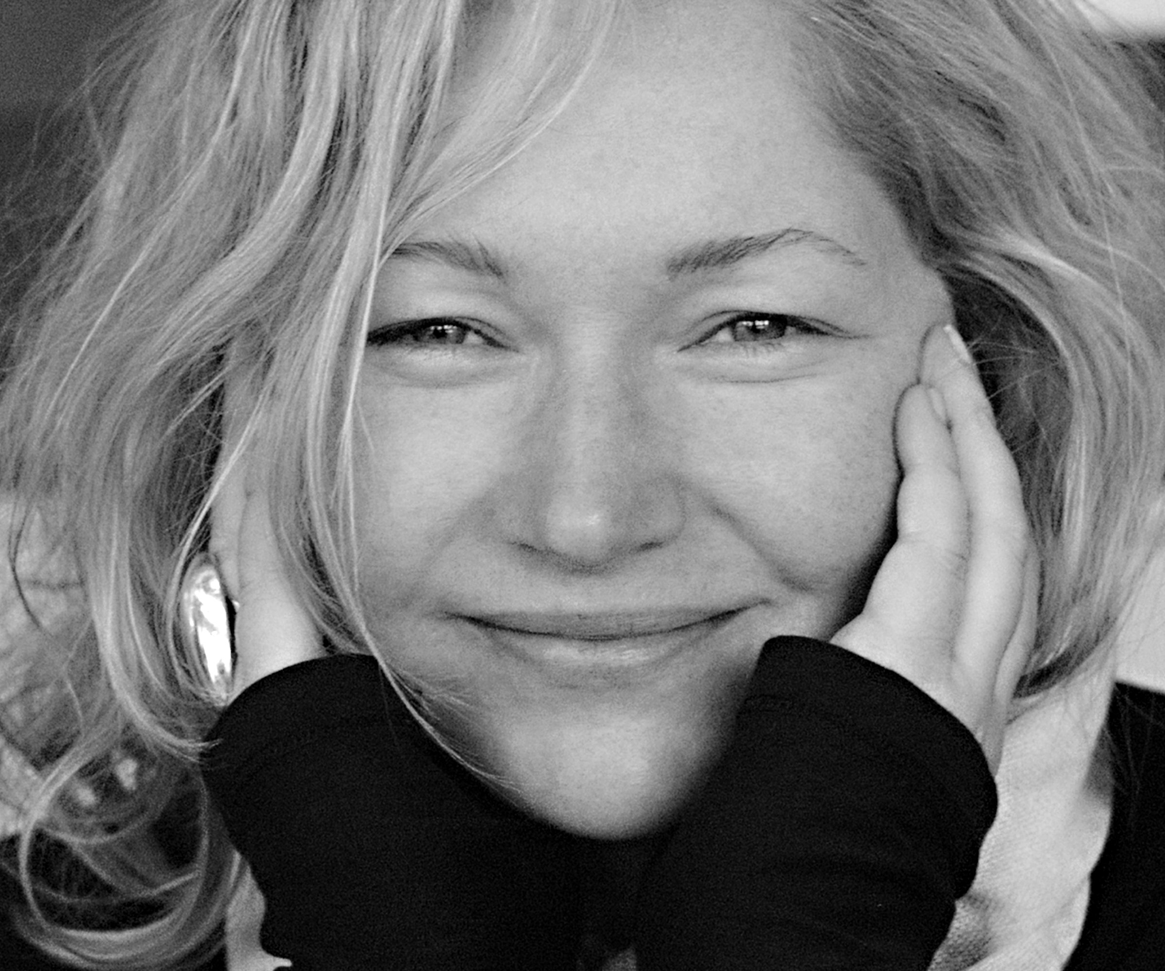 Black-and-white portrait of Margie Miller, with shoulder-length blonde hair, resting her face against her hands.