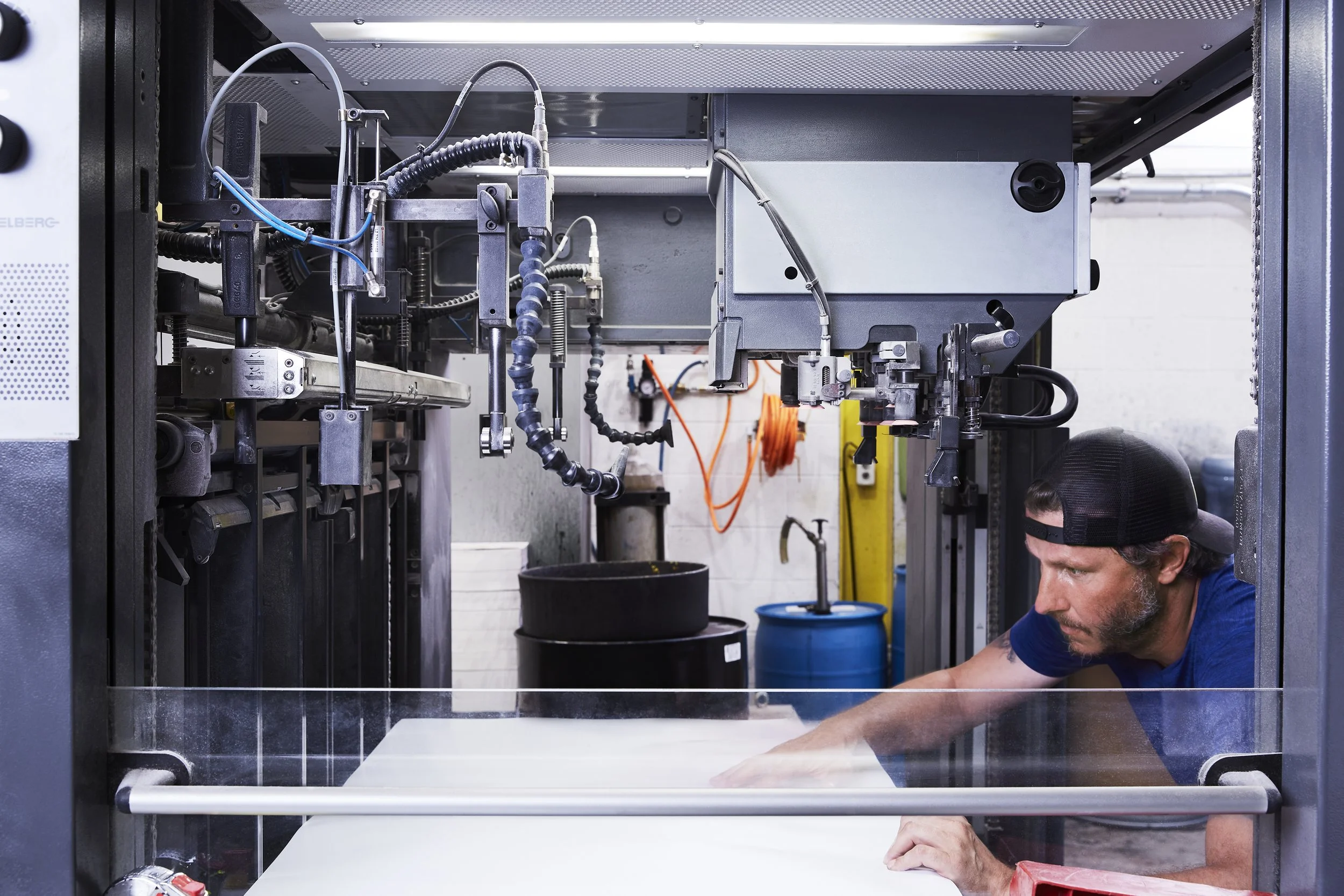 Art-directed brand photography for Proprint, capturing an employee carefully positioning materials in a printing press, reflecting the precision and attention to detail behind the company's commitment to excellence.